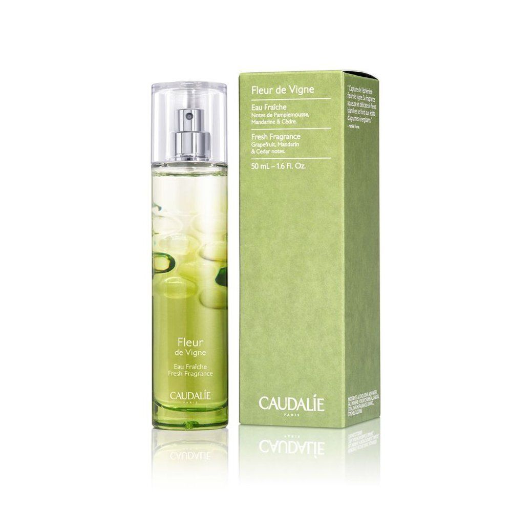 Glasflasche mit Zerstäuber und grüner Kartonverpackung. Beide mit "Fleur de Vigne" und "Caudalie" beschriftet.