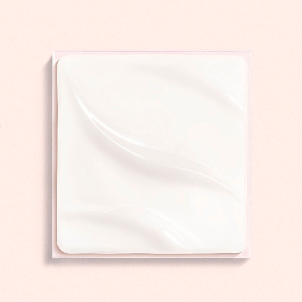 Quadratische, weiße Creme auf rosa Hintergrund. Leichte Wellenstruktur.
