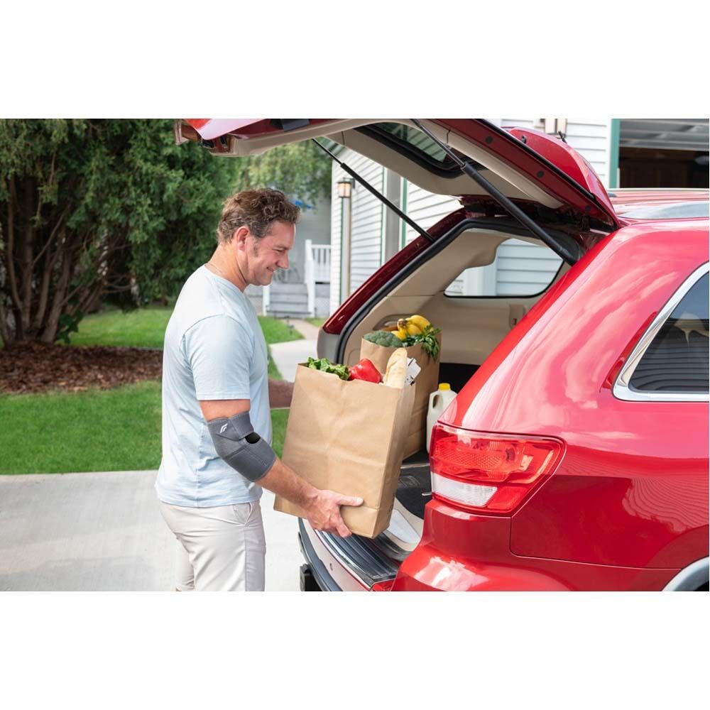 FUTURO™ Ellenbogenbandage, grau. Produktansicht, ohne Verpackung, auf Arm. Flexibles Material, anatomische Form.