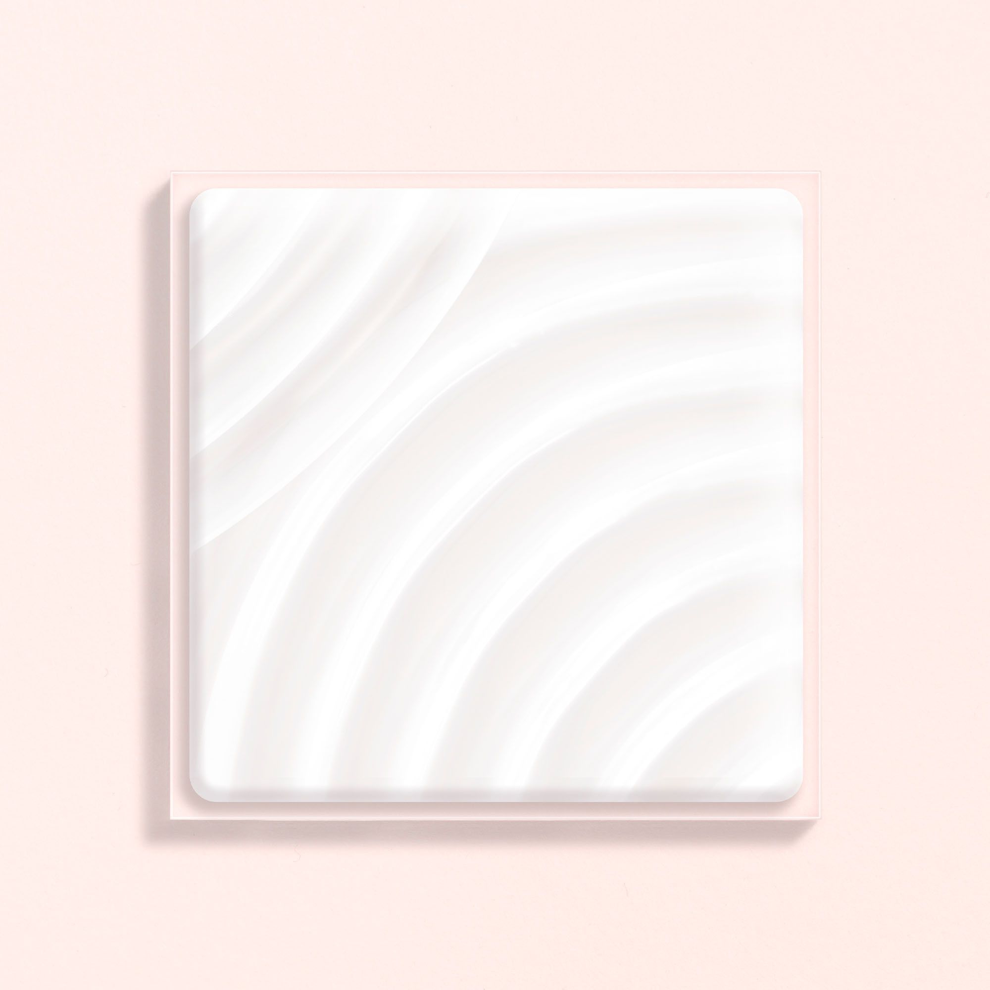 Quadratische weiße Creme in einer rechteckigen rosa Schale, mit geschwungenen Linien.
