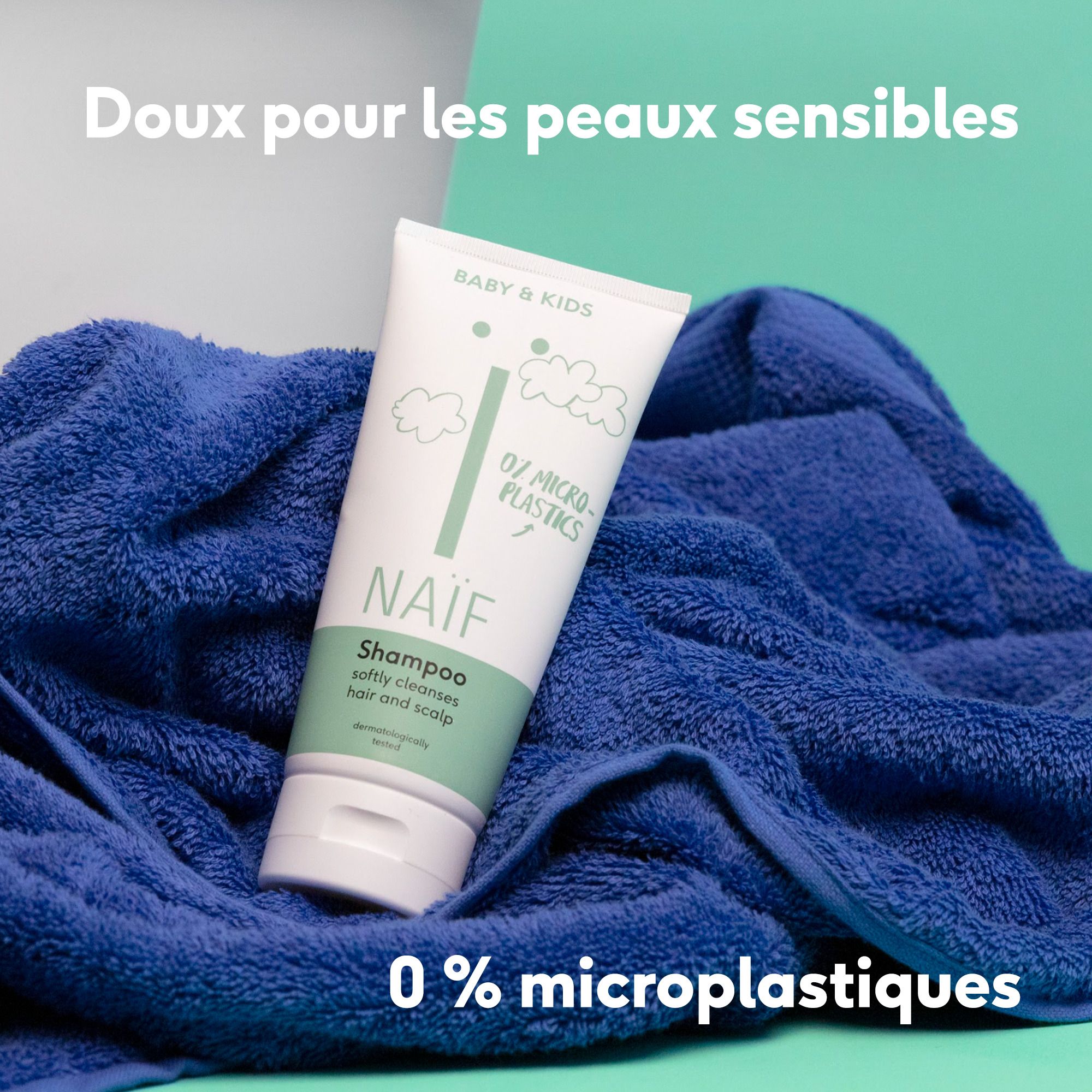 Tube de shampooing sur une serviette bleue. Texte : Doux pour les peaux sensibles, 0% microplastiques.