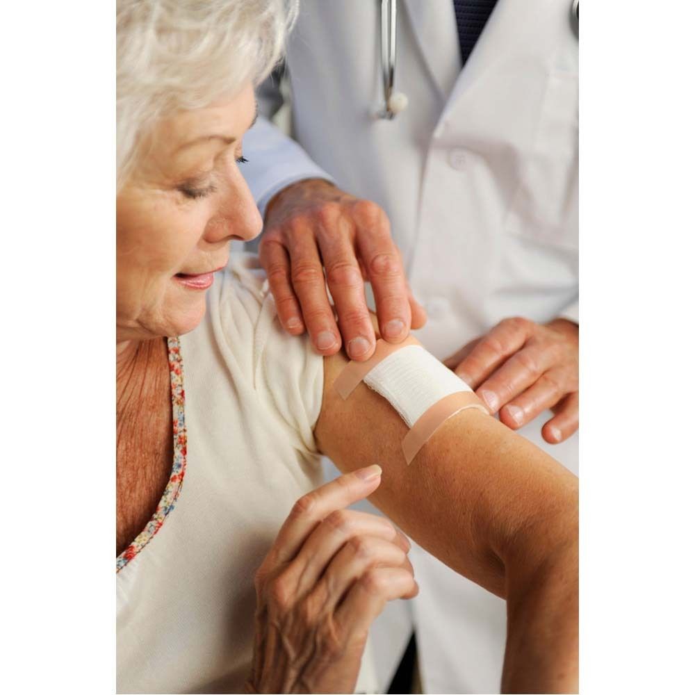 Nexcare Textilband in transparenter Verpackung. Rolle mit rotem Kern und beigem Band. Produktname sichtbar.