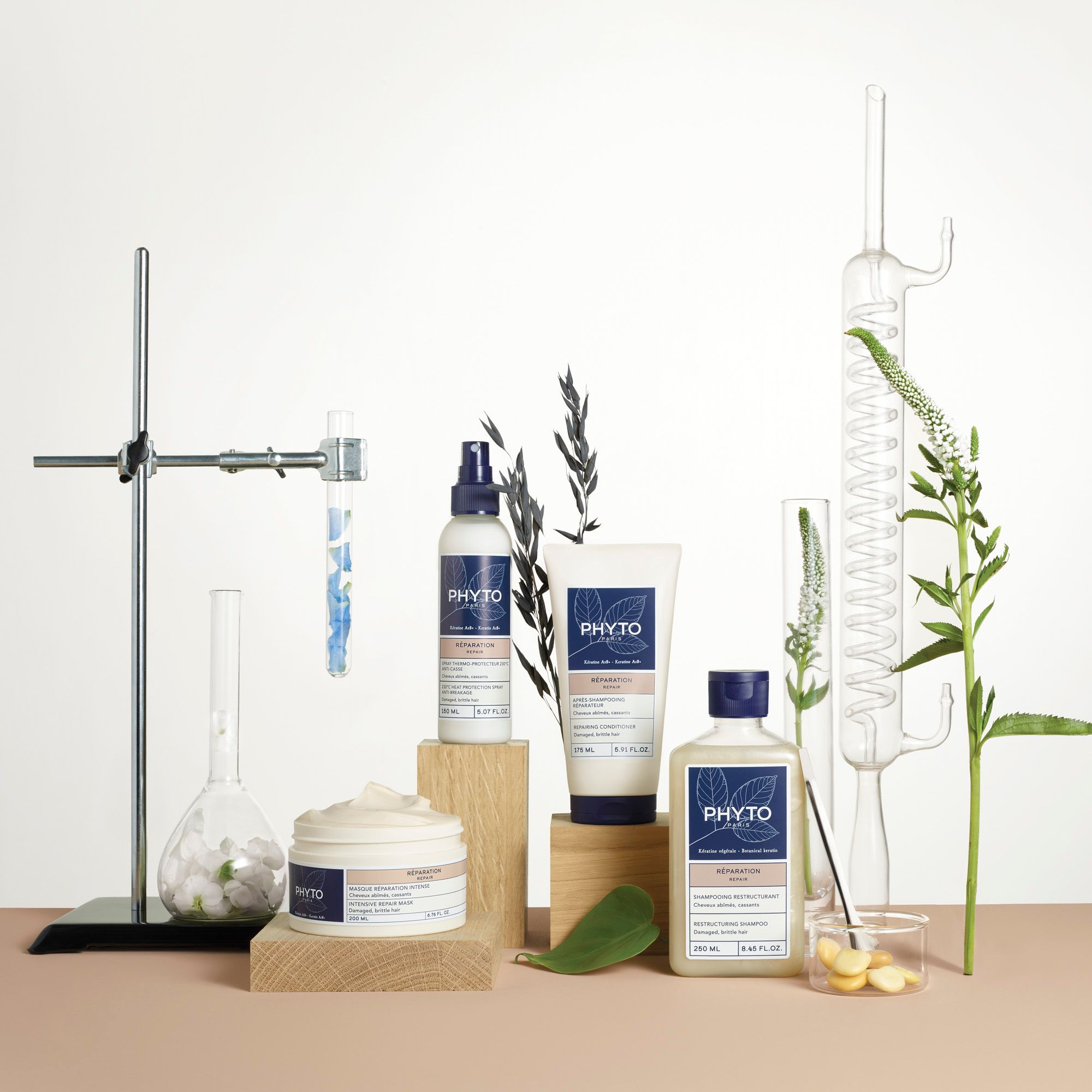 Plusieurs flacons et contenants de produits, entourés de plantes et d'appareils de laboratoire.