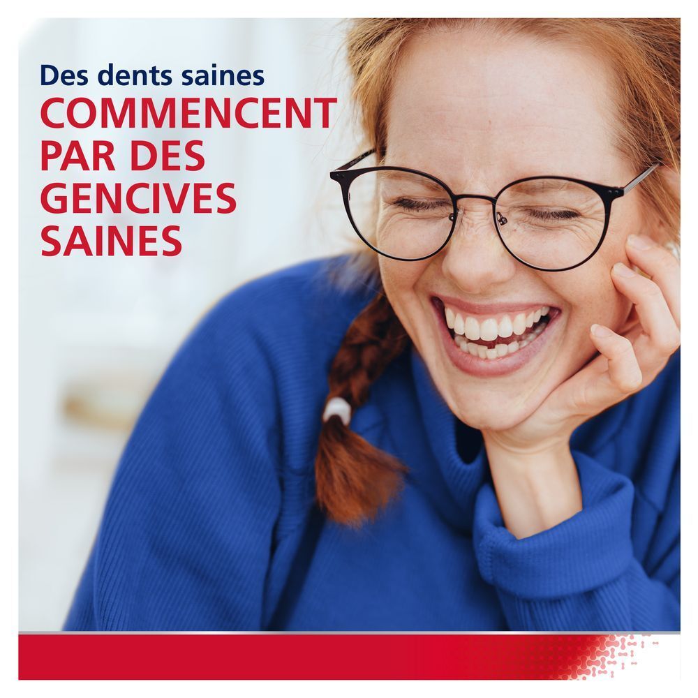 Femme souriante. Dents saines. Vêtements bleus. Fond blanc.