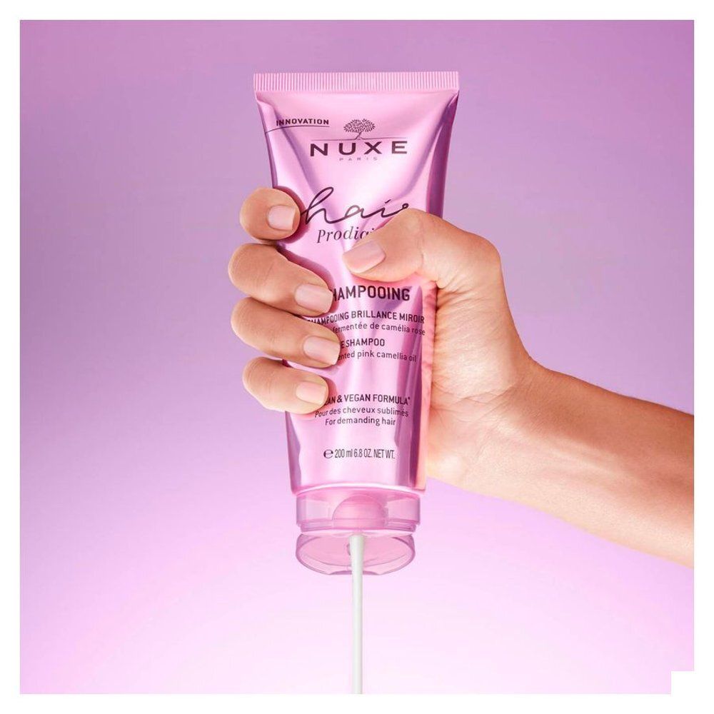 Gros plan d'une fleur de camélia rose, ingrédient du shampooing Nuxe Hair Prodigieux.