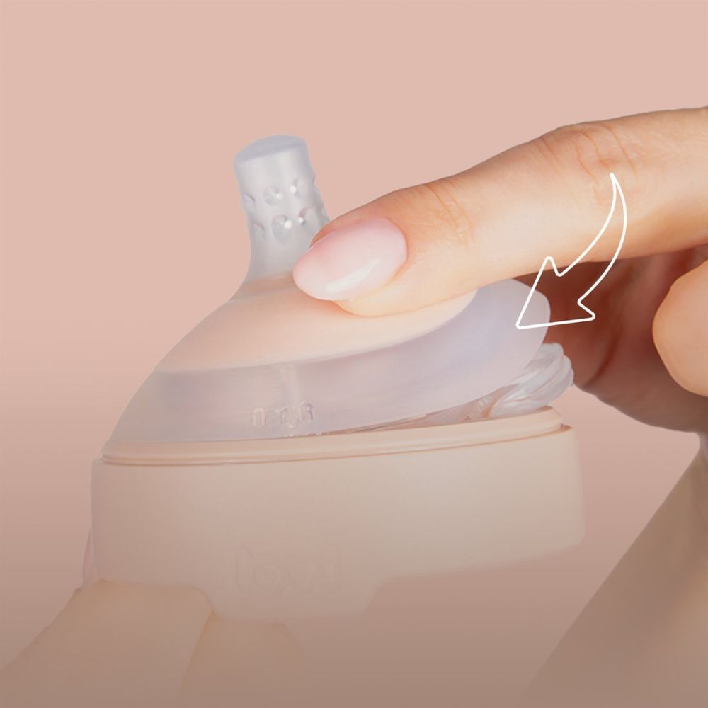 Hand zeigt, wie man einen Sauger anbringt. Rosa Basis, transparenter Aufsatz.