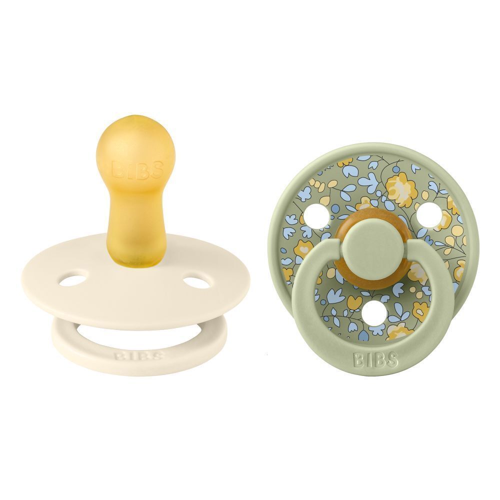 Deux sucettes BIBS. Tétine jaune, bouclier blanc. Bouclier vert à motifs floraux.