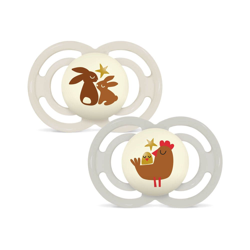 Zwei Schnuller mit Tiermotiven: Hasen und Huhn mit Küken. Helle Farben, symmetrisches Design.