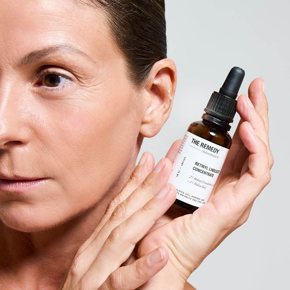 Flasche mit THE REMEDY Retinyl Linoleate Concentrate Serum, gehalten von einer Frau.