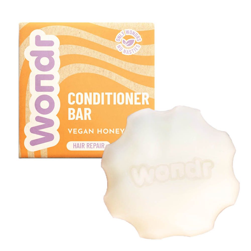 Produit et emballage. Le Conditioner Bar est blanc et en forme de fleur. L'emballage est orange avec le nom du produit.