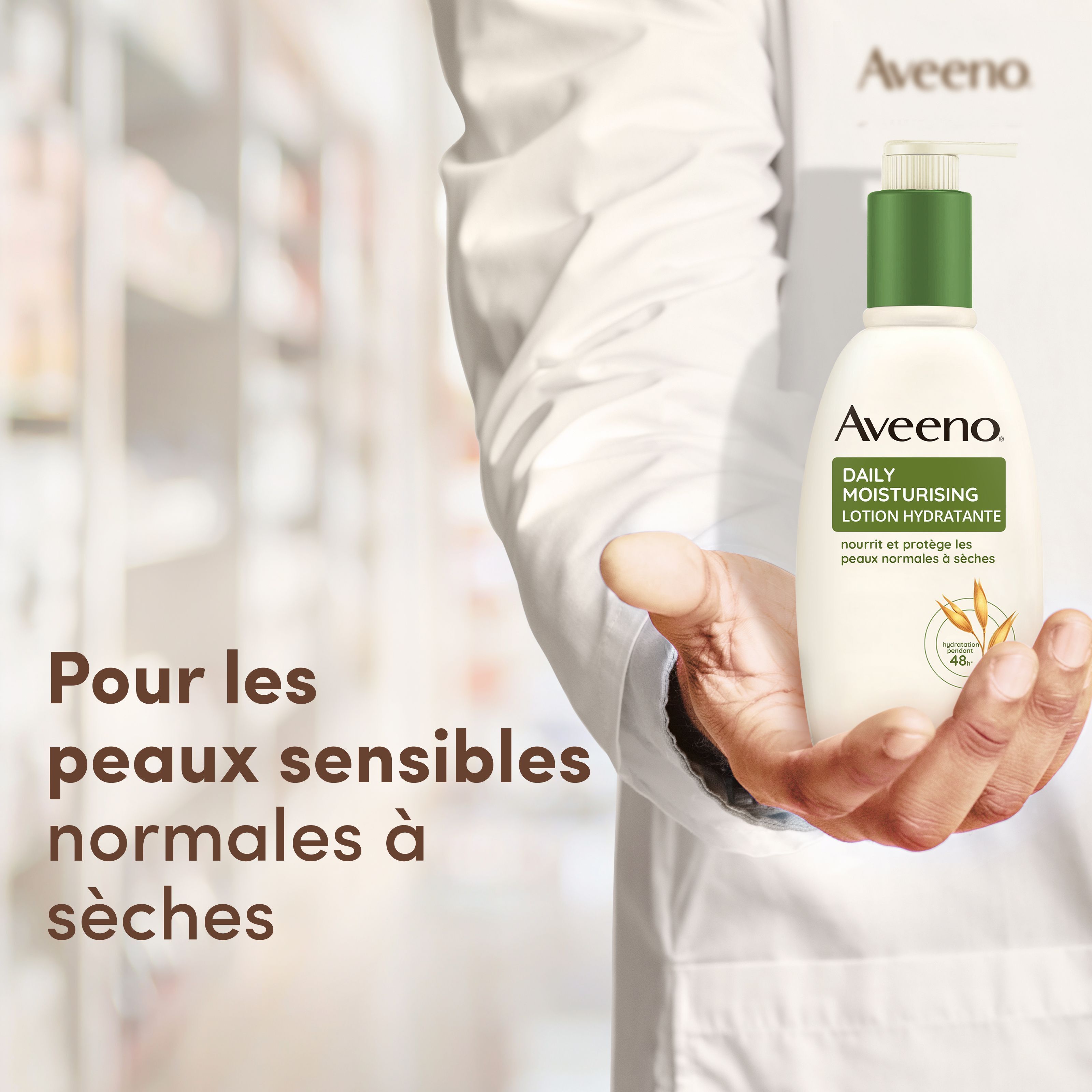AVEENO Daily Moisturising Lotion hydratante. Main tenant un flacon. Texte: Pour les peaux sensibles normales à sèches.