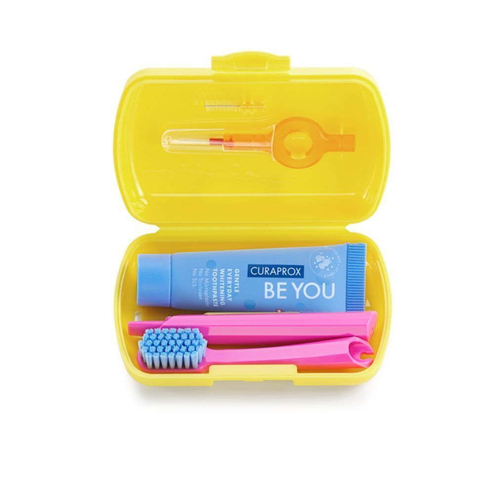 Trousse de voyage jaune ouverte. Contient brosse à dents, dentifrice et brossettes interdentaires. Logo Curaprox.