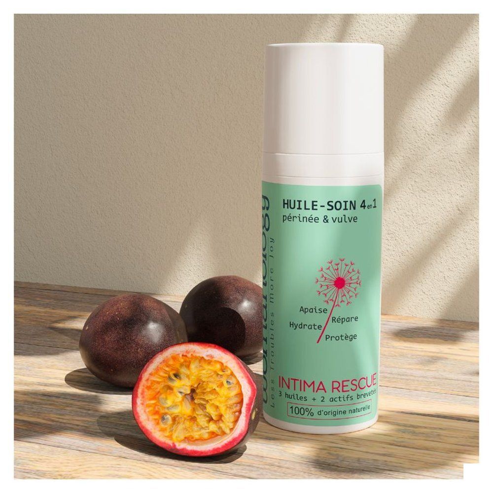 Flacon Womanology Intima Rescue, à côté des fruits de la passion. Produit avec texte: Huile-Soin 4-en-1, Périnée & vulva. 100% naturel.