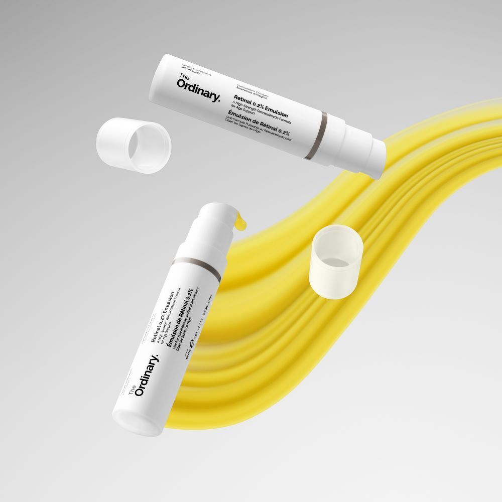 Zwei Flaschen mit Pumpe, gelbe Flüssigkeit. Marke: The Ordinary. Hintergrund: gelbe Welle.