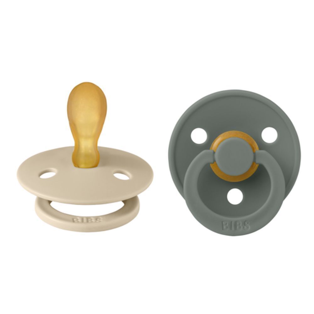 Deux sucettes BIBS. Beige et vert. Forme symétrique. Tétine jaune. Anneau avec logo BIBS.
