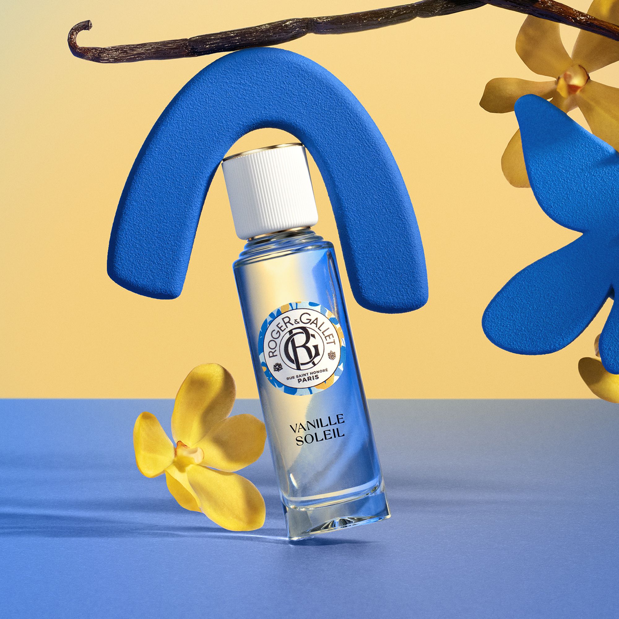 Flacon avec bouchon blanc. Marque: Roger&Gallet. Texte Vanille Soleil. Sur fond bleu.