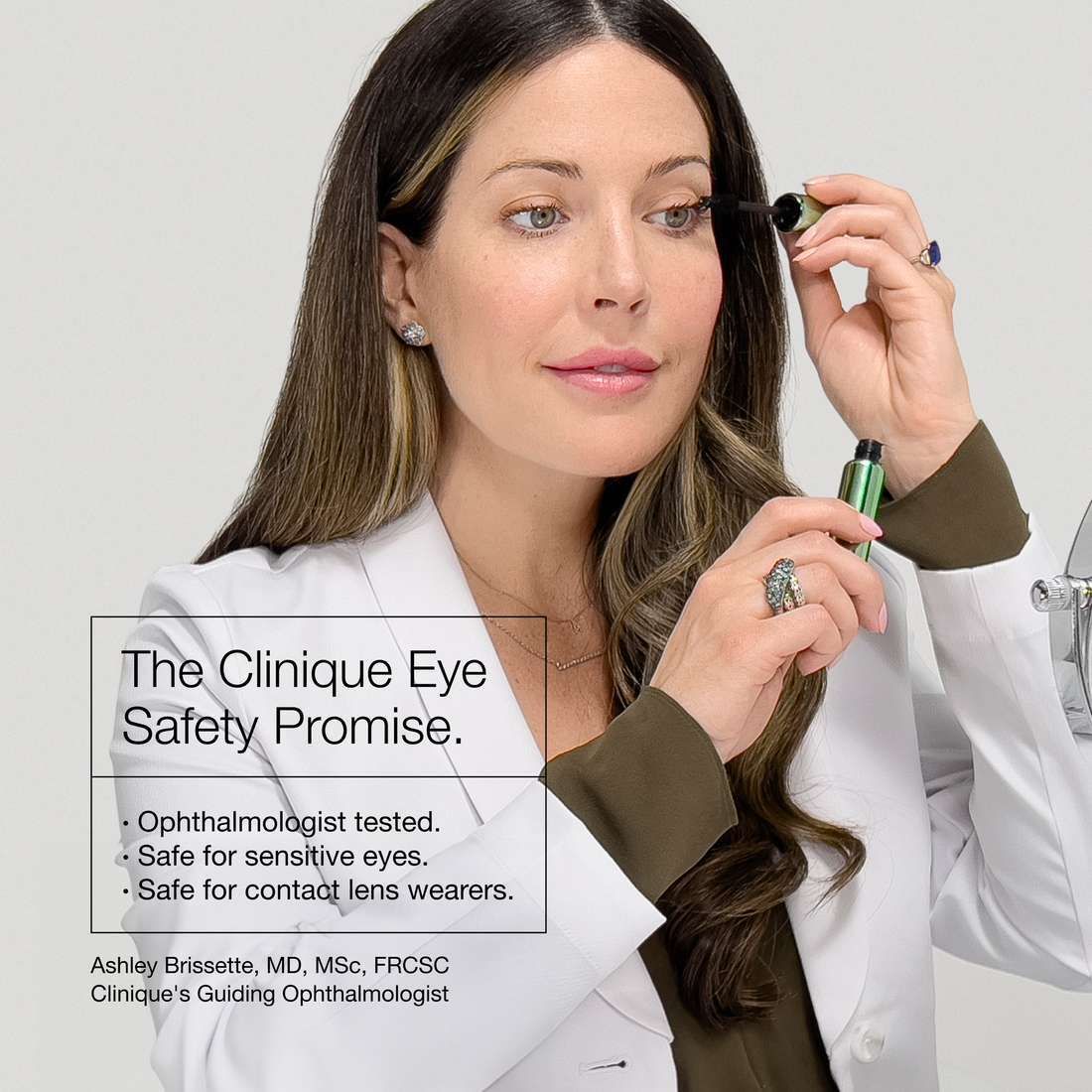 Frau trägt Mascara auf. Text über die Augensicherheit von Clinique.
