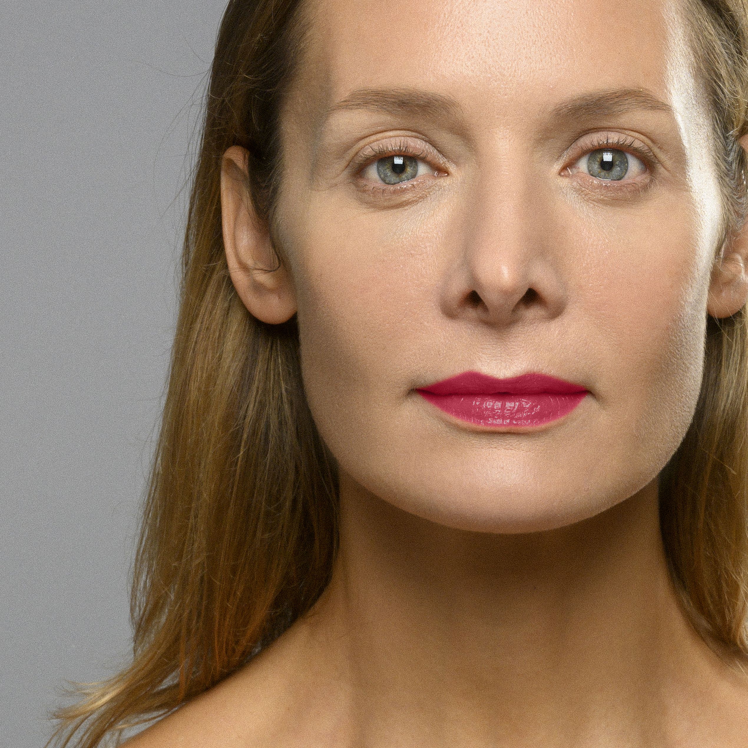 Portrait d'une femme portant du rouge à lèvres. Les lèvres sont maquillées d'une teinte rouge.