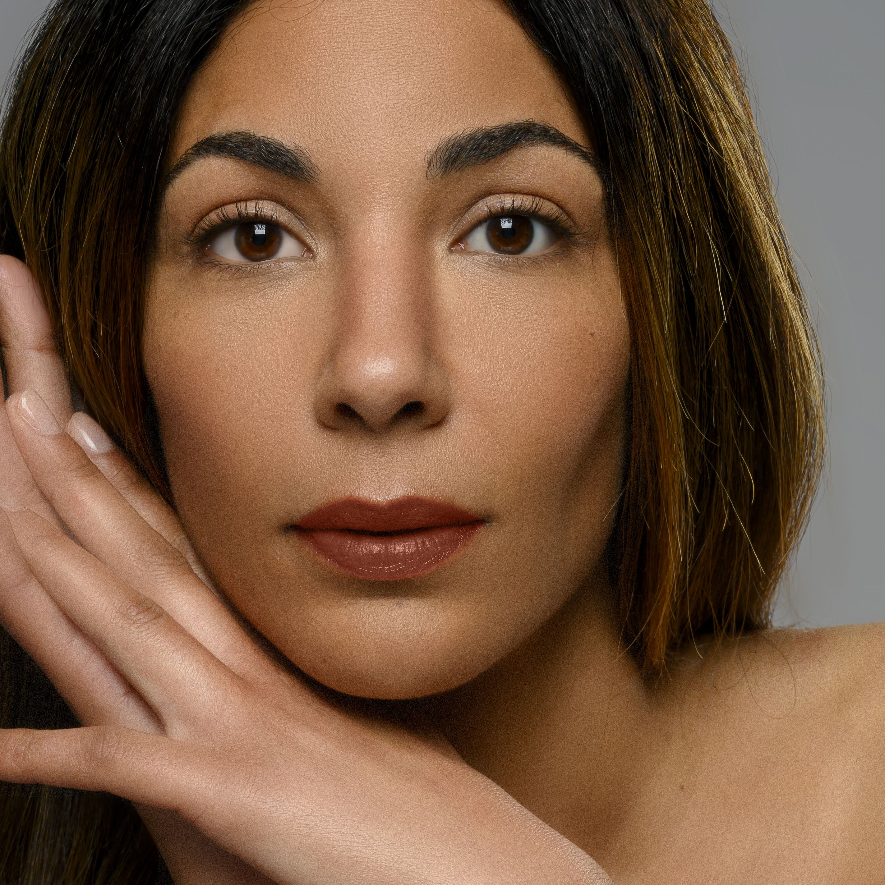 Portrait d'une femme avec du rouge à lèvres. La femme a les lèvres marron peintes avec du rouge à lèvres.