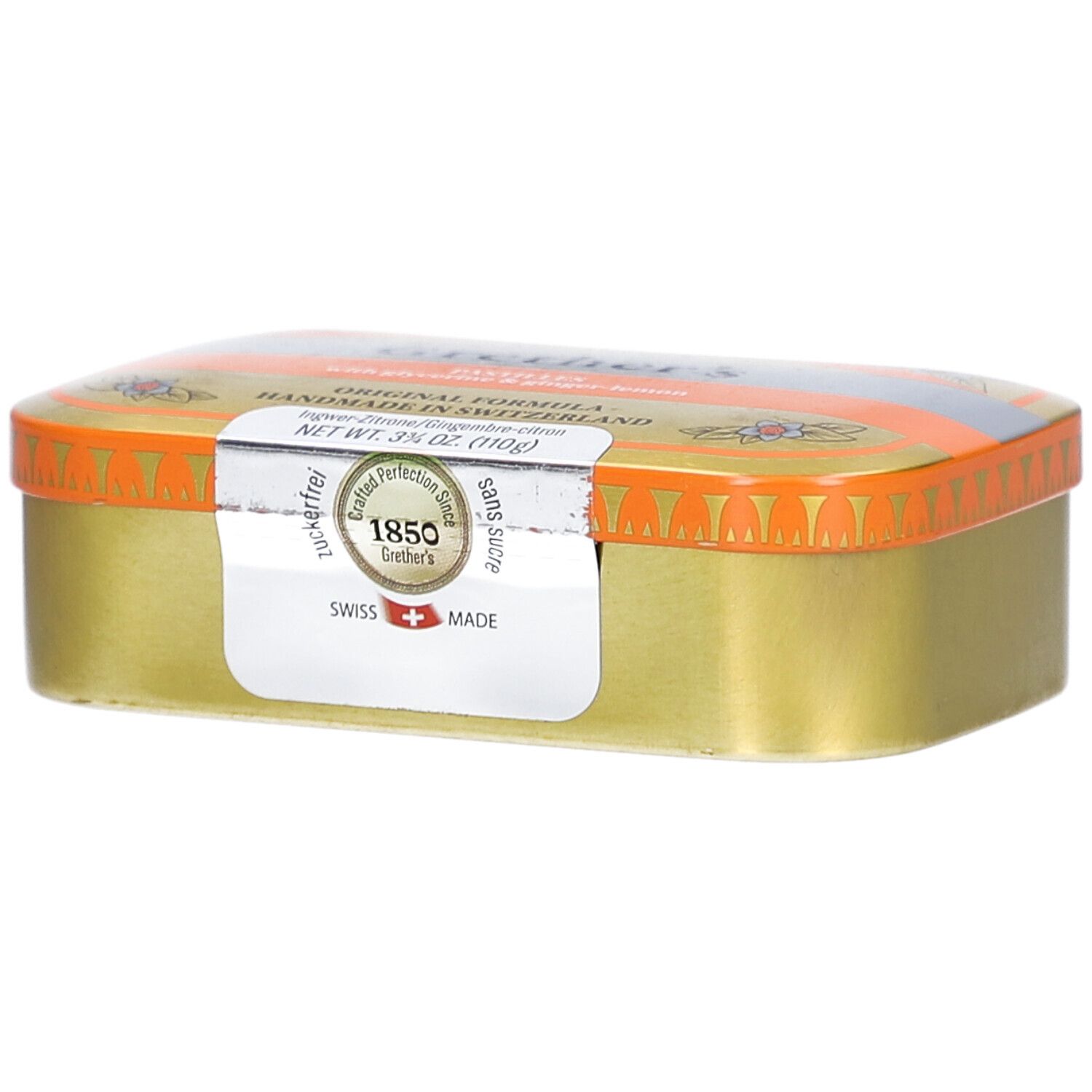 Goldfarbene Pastillendose mit orangefarbenem Deckel. Aufkleber mit Text. "Swiss Made".