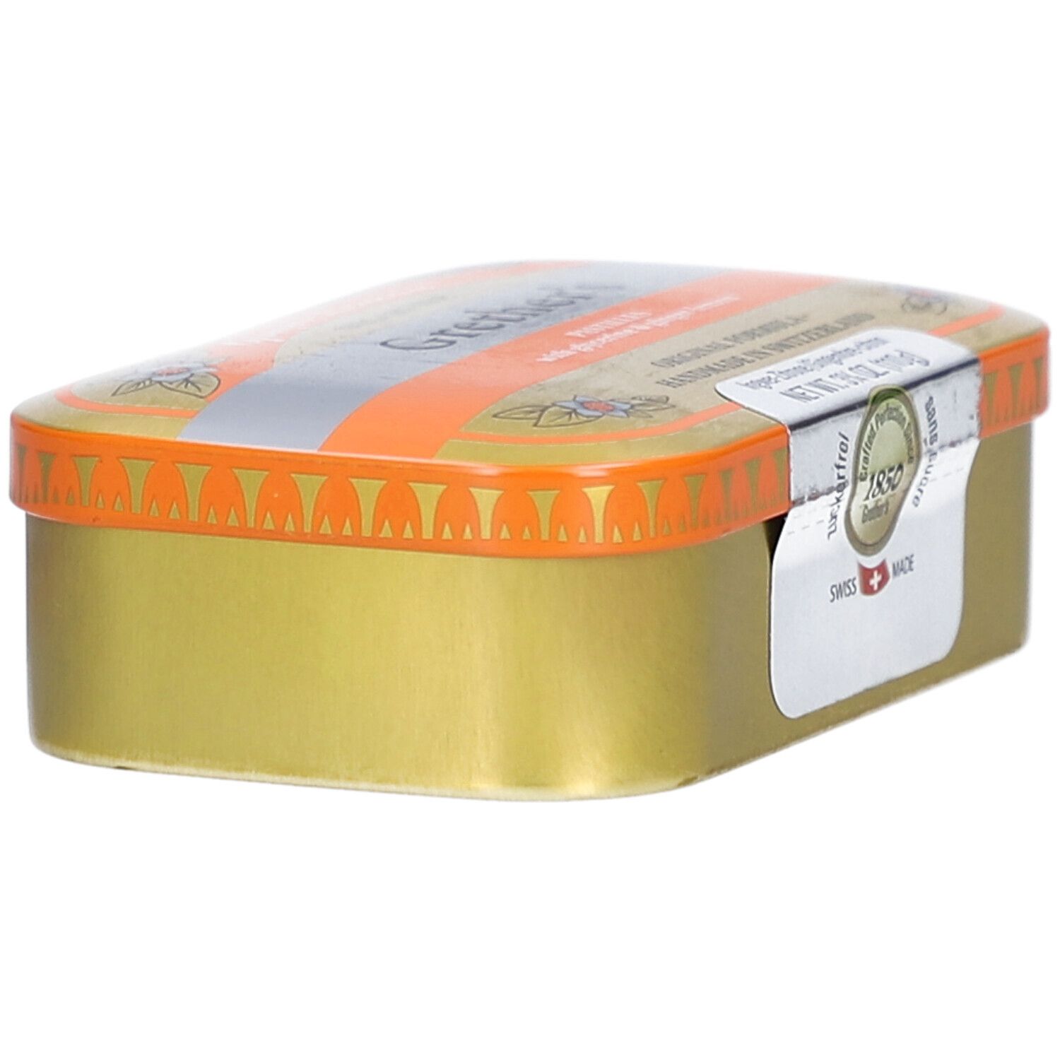 Goldfarbene Pastillendose mit orangefarbenem Deckel. Aufkleber mit Text. "Swiss Made".