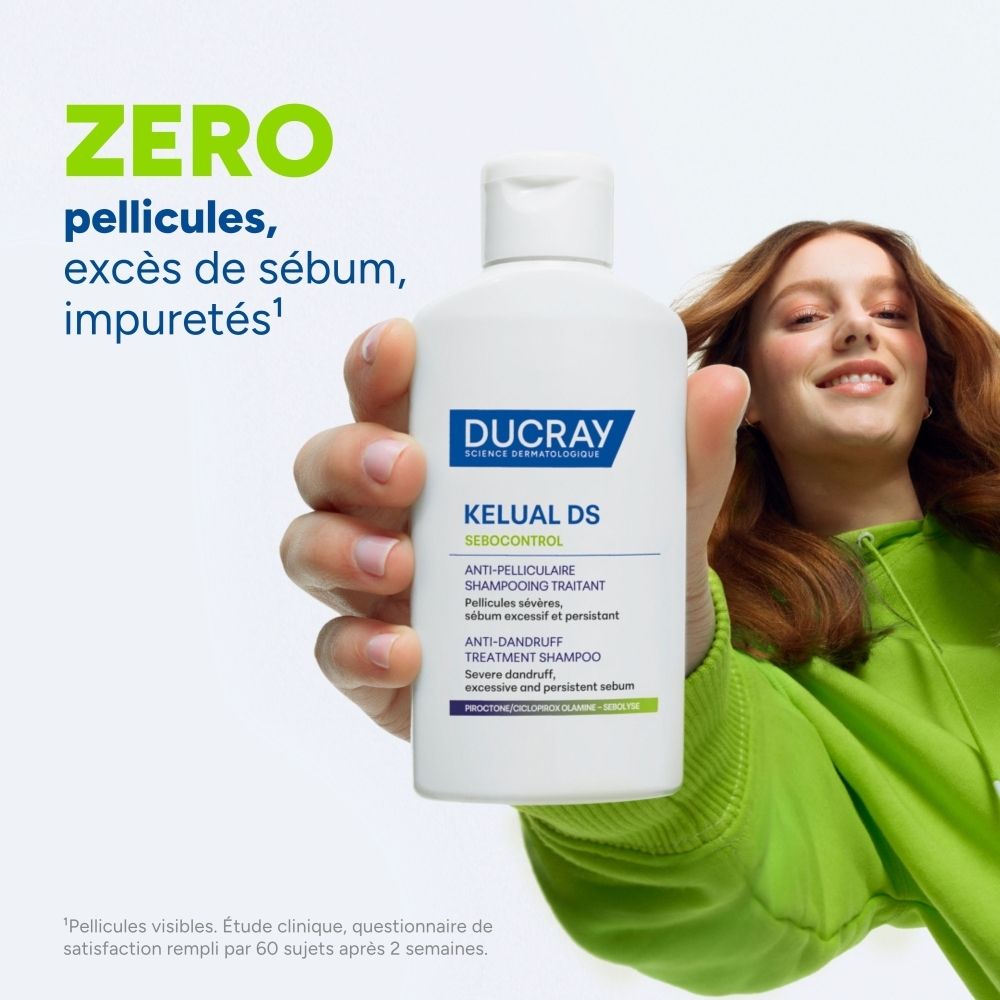 Ducray Kelual DS Shampoo: Weiße Flasche in der Hand einer Person, mit Text über Schuppenfreiheit und Talgkontrolle.