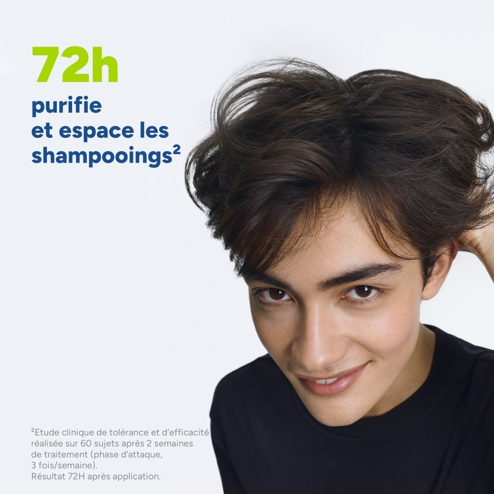 Nahaufnahme eines jungen Mannes mit vollem Haar, der sich die Haare berührt. Text über 72 Stunden Reinigung und verlängerte Shampoo-Intervalle.