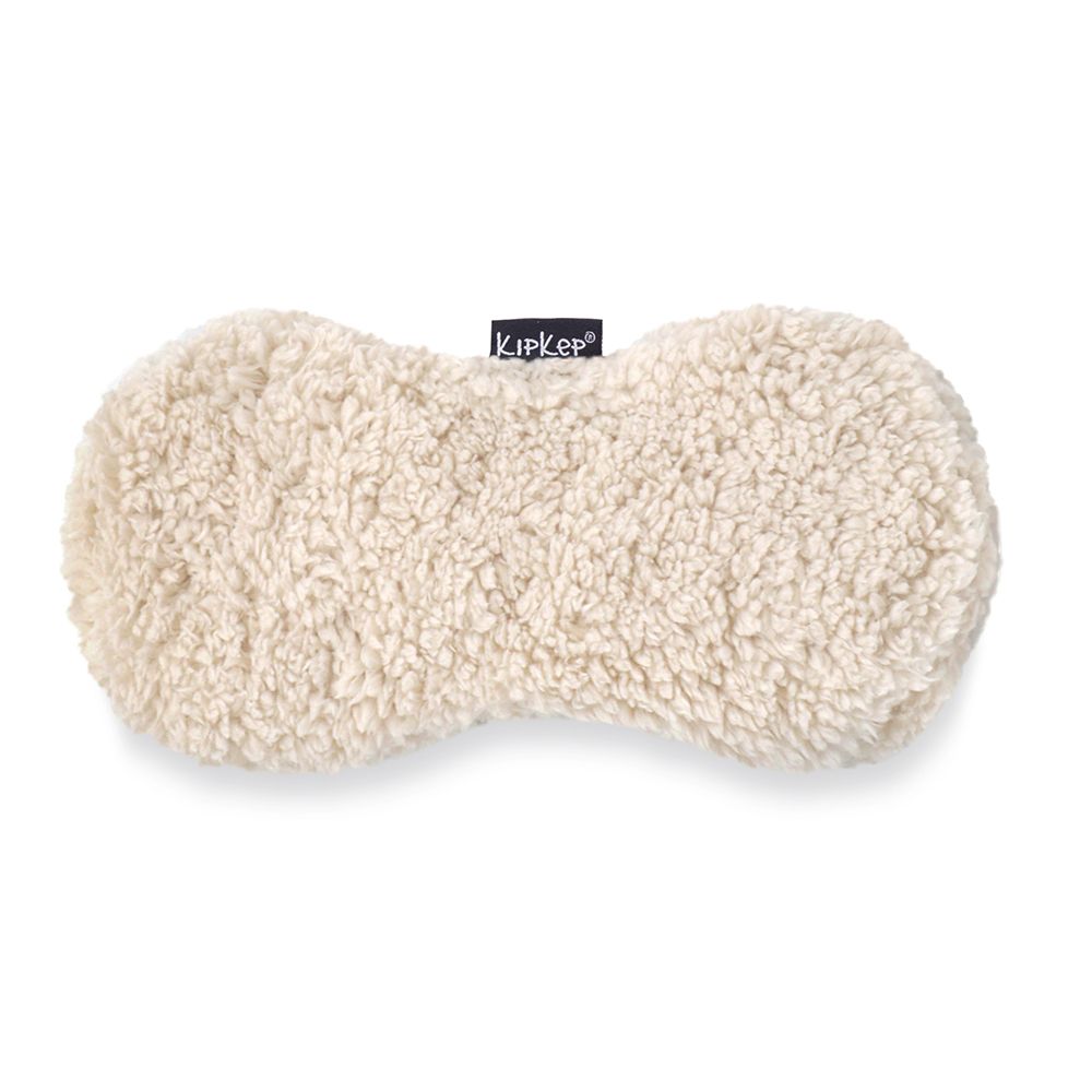 Coussin chauffant KIPKEP beige, aspect teddy. Forme ovale avec logo KIPKEP.