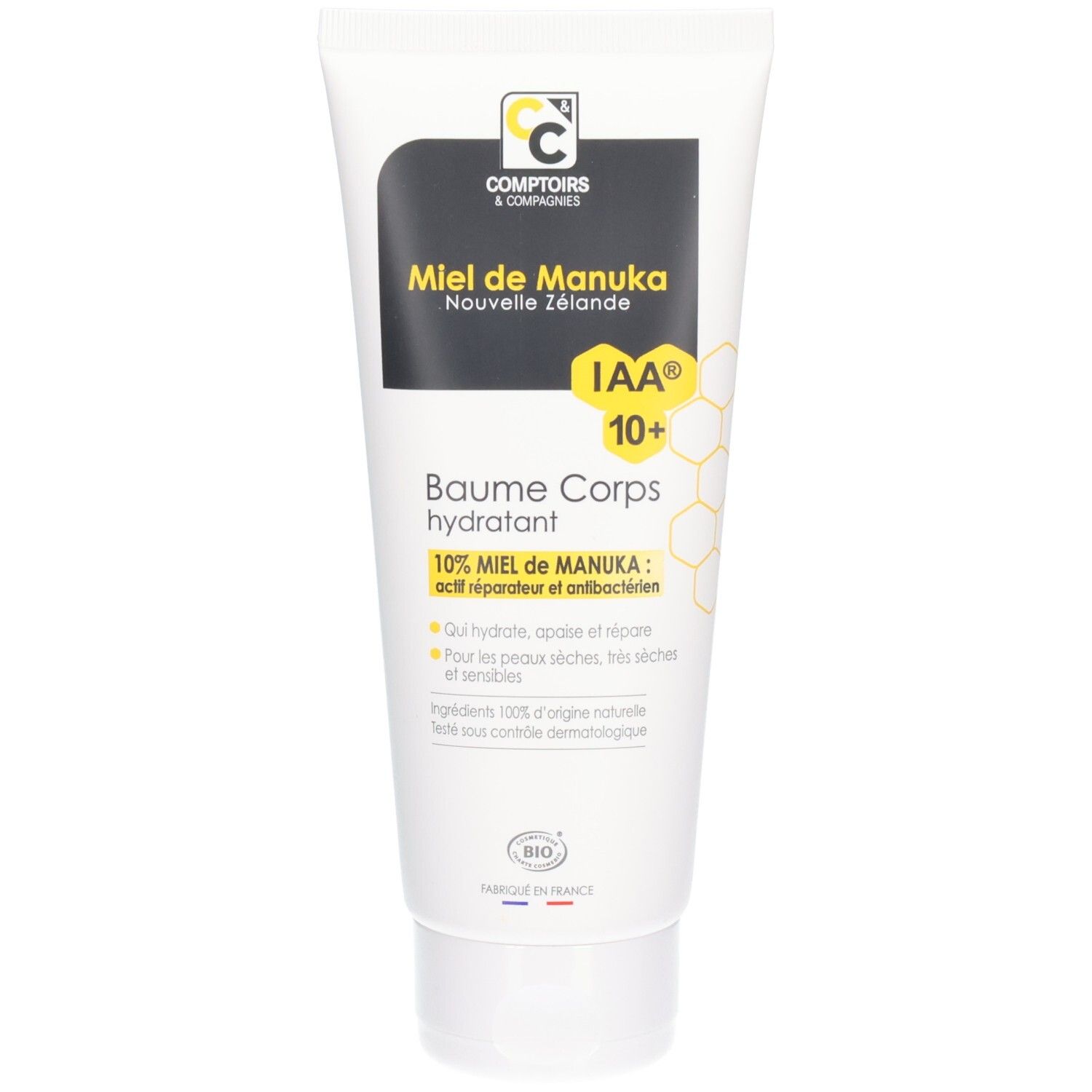 Weißer Tubenbehälter mit schwarzem Etikett. Text: Miel de Manuka, IAA 10+, Baume Corps hydratant. Bio-Siegel.