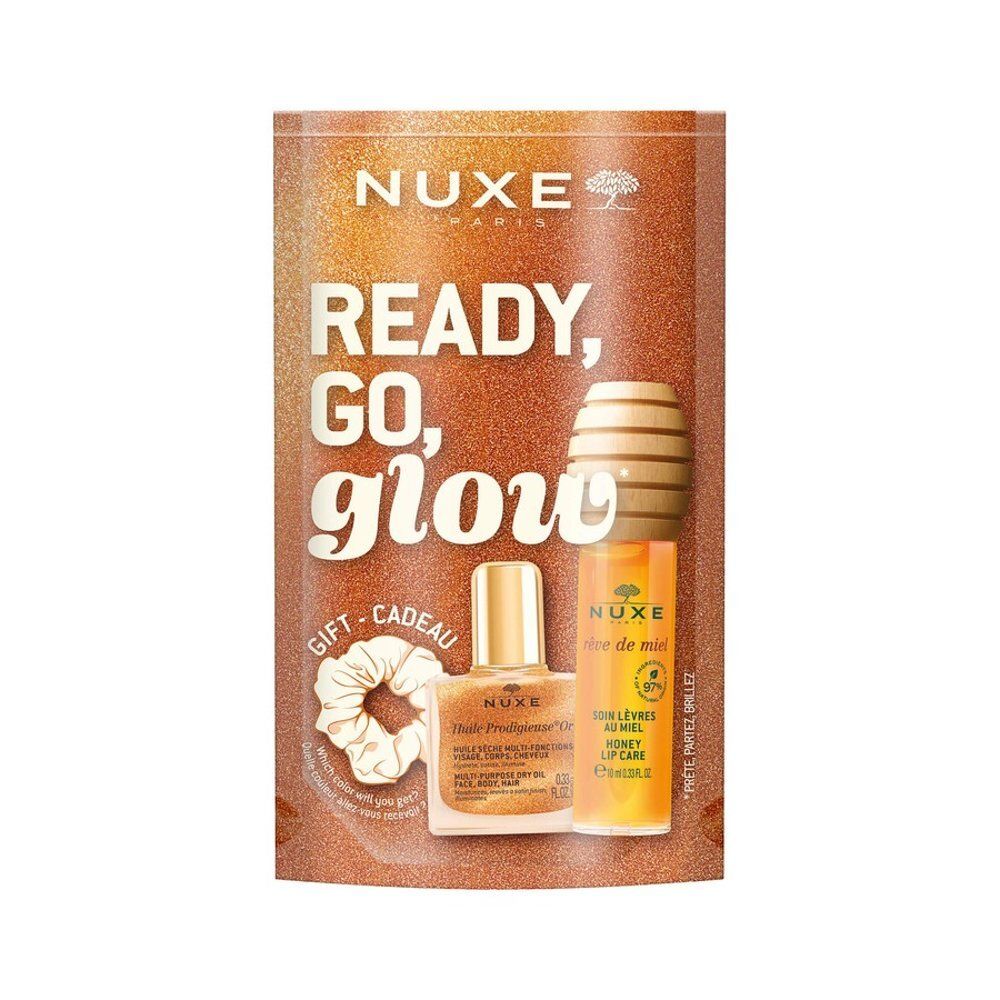 Coffret cadeau Ready, Go, Glow avec huile, soin lèvres et chouchou. Emballé dans un sac orange pailleté.