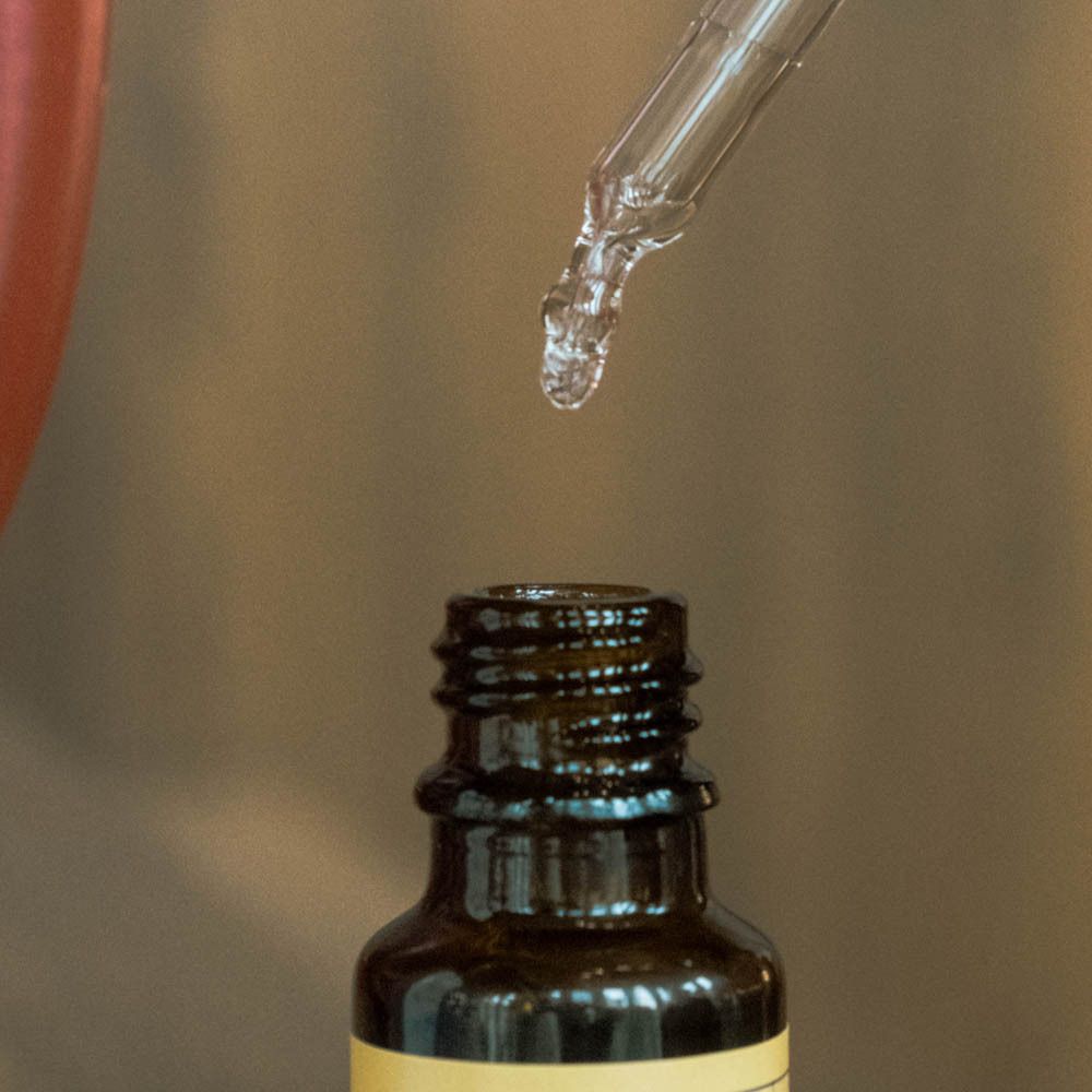 Gros plan d'une pipette doseuse avec des gouttes. Le liquide coule de la pipette.