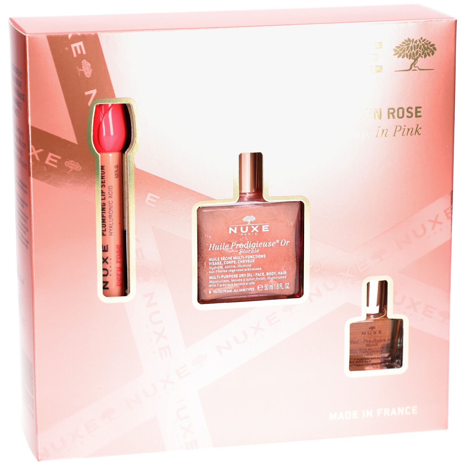 Rosa Geschenkbox mit drei Produkten. Sichtbar: Lippenstift, Ölflasche und kleine Flasche. Text: Nuxe Paris, Glow en Rose.