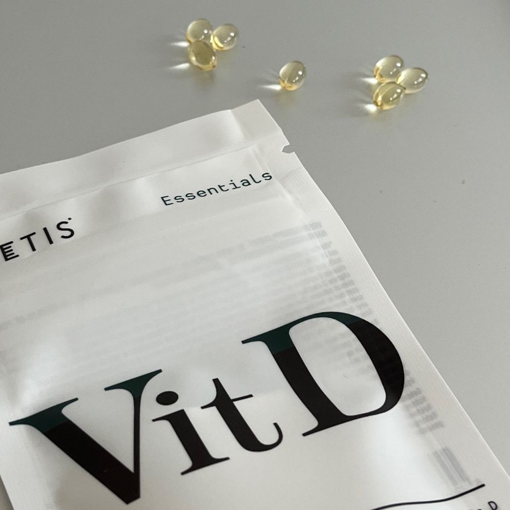 Gélules et emballage de Metis Essentials Vit D. Quelques gélules à côté de l'emballage.