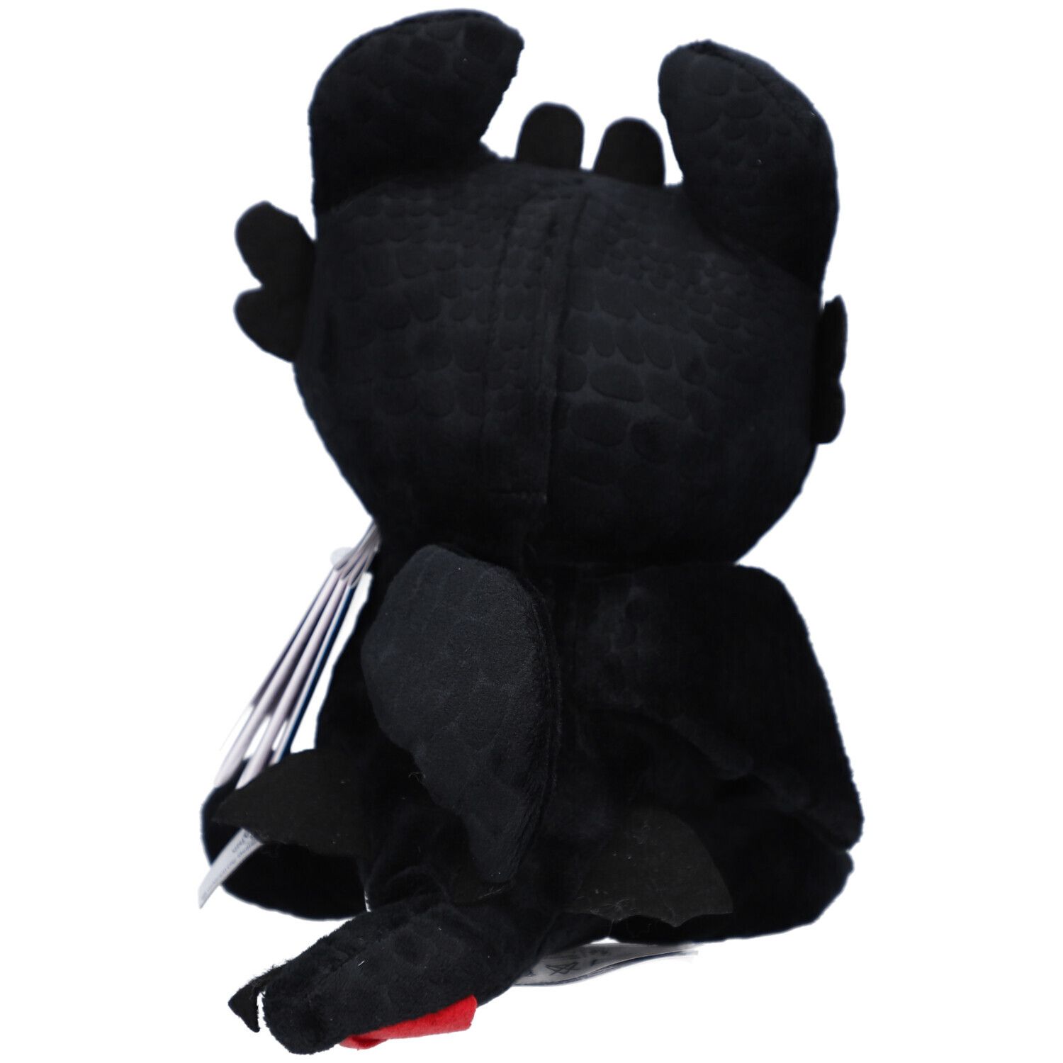 Rückansicht eines schwarzen Plüschtiers in Drachenform. Sichtbar sind Flügel, Ohren und ein roter Akzent.