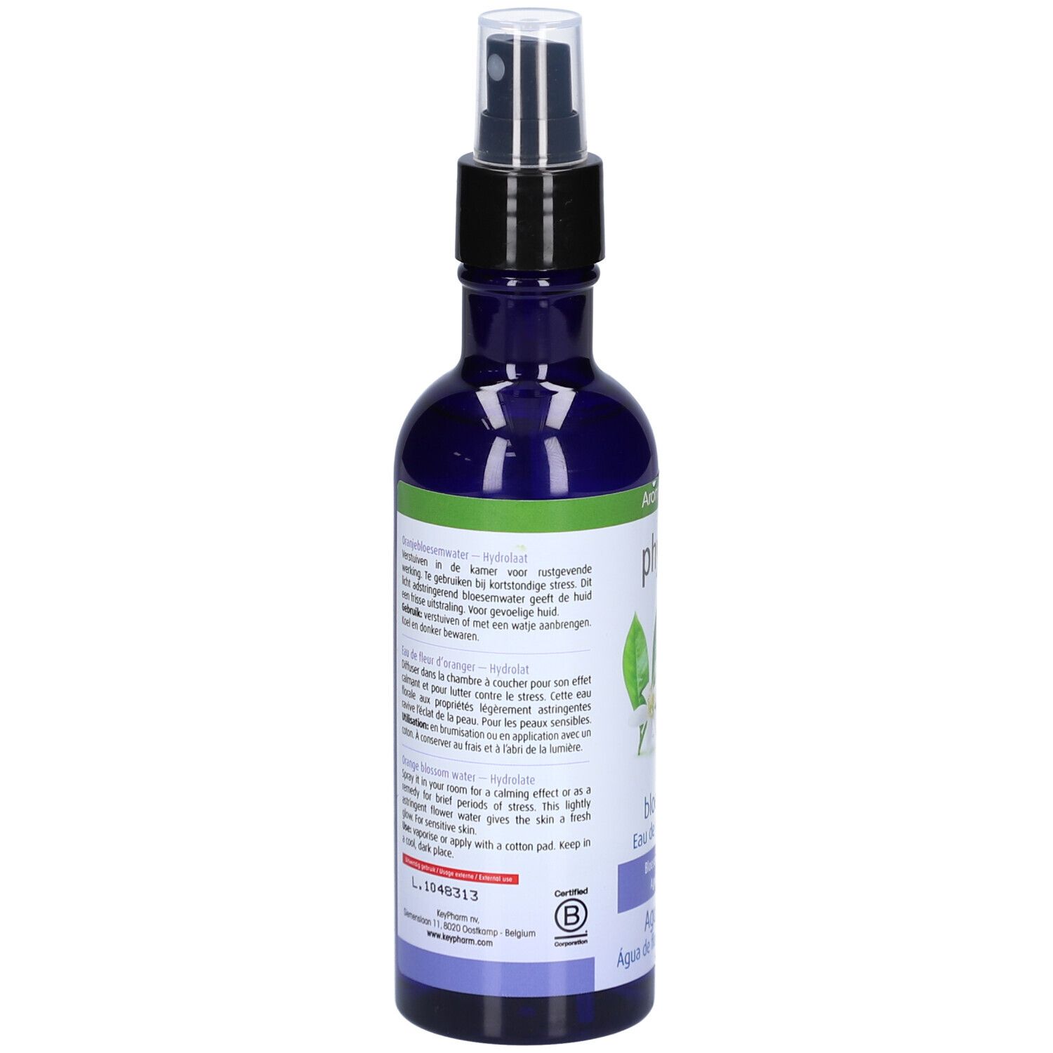 Rückseite der blauen Flasche. Text in mehreren Sprachen. Grüner Streifen mit weißem Text. Schwarzer Zerstäuber.