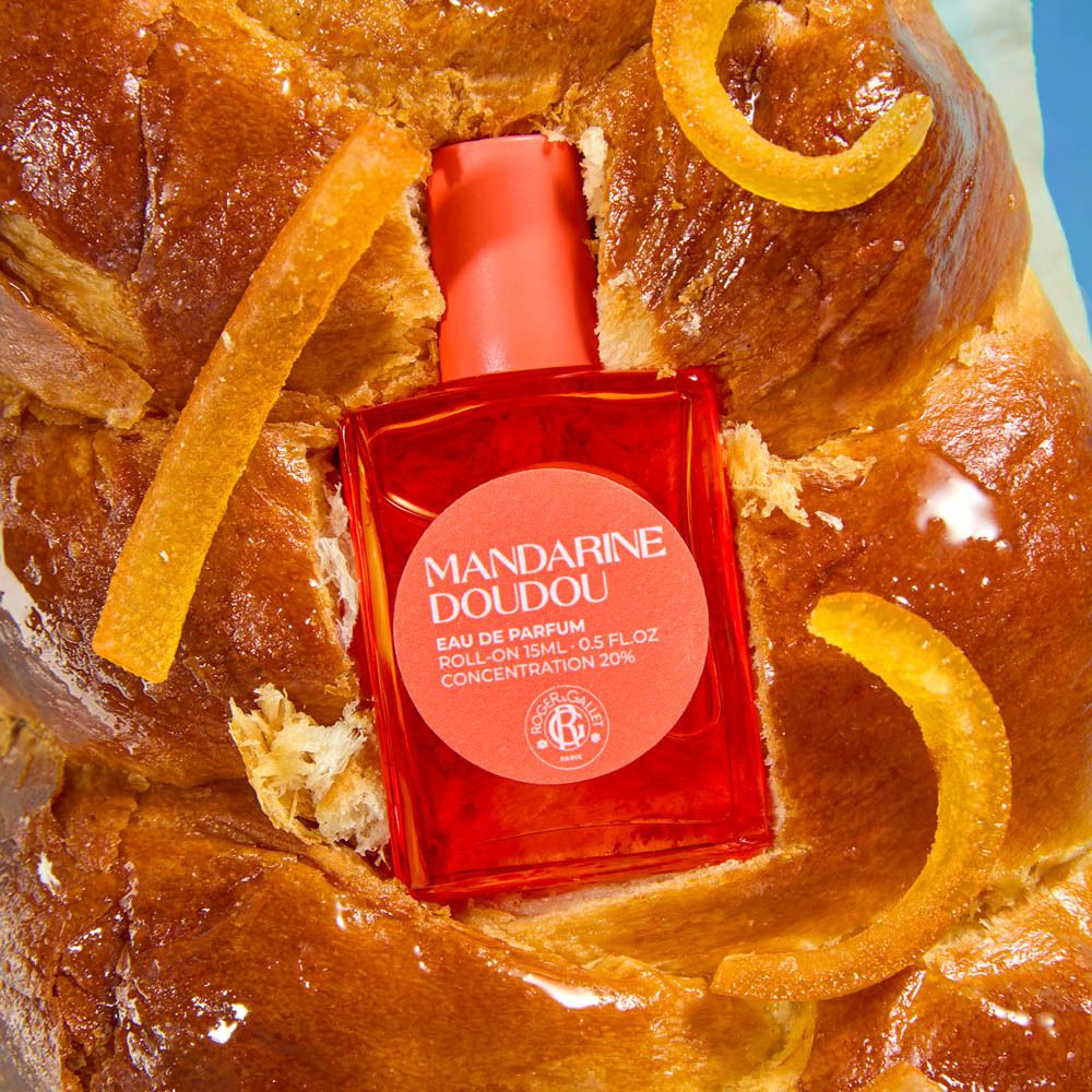 Flacon sur brioche. Flacon: Mandarine Doudou Eau de Parfum. Orange. Inscription.