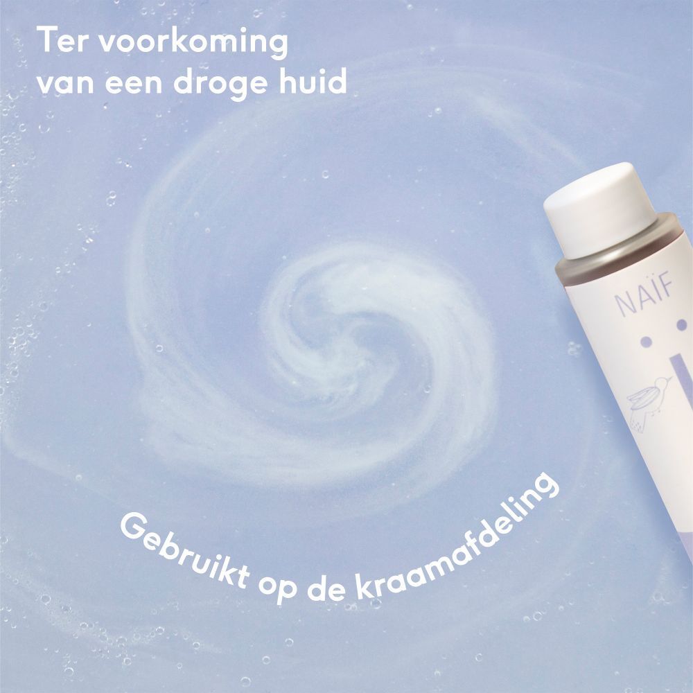 Huile de bain Naïf dans l'eau. Mousse blanche. Texte: 'Ter voorkoming van een droge huid'.