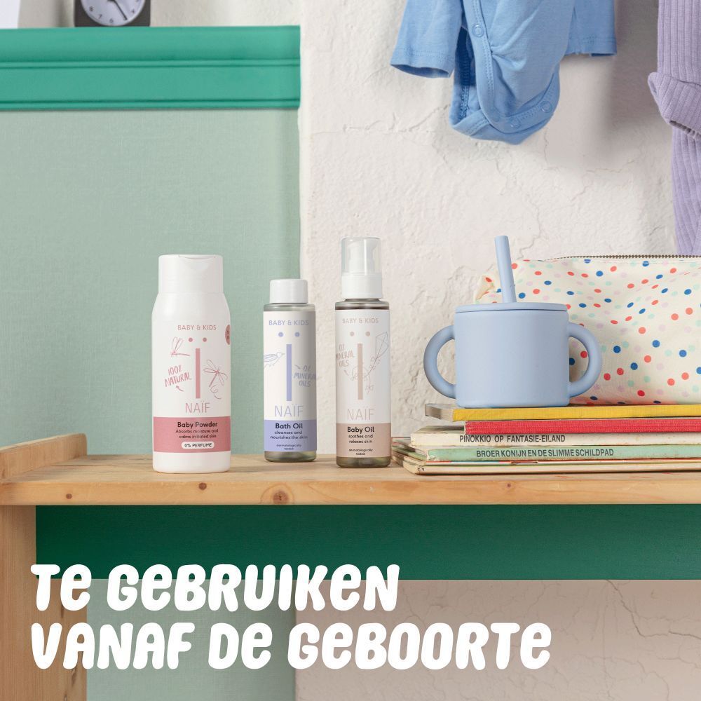 Trois produits Naïf sur une étagère. Huile de bain, huile pour bébé et spray. Texte: 'Te gebruiken vanaf de geboorte'.