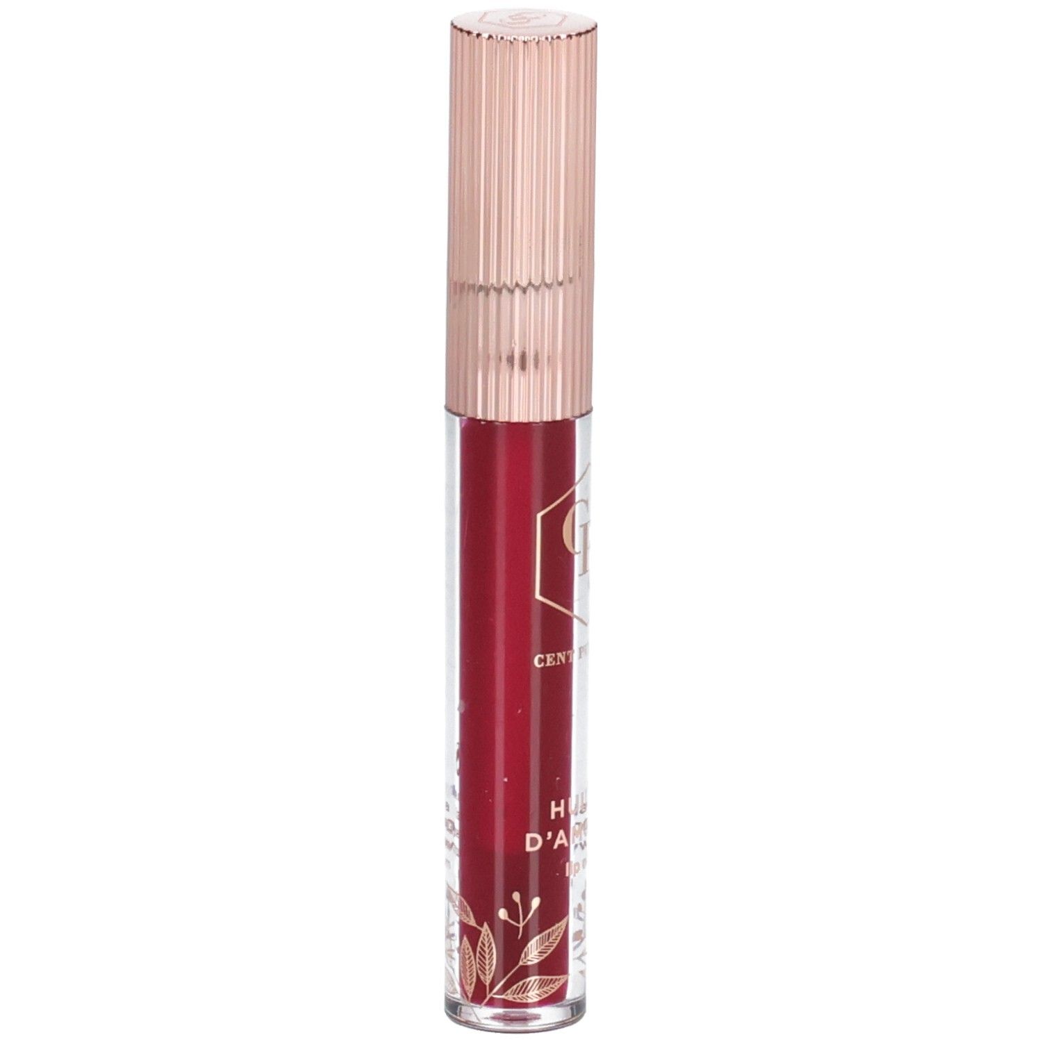 Huile à lèvres dans un flacon transparent avec un bouchon or rose. Le contenu est rouge. Des décorations dorées sont visibles sur le flacon.