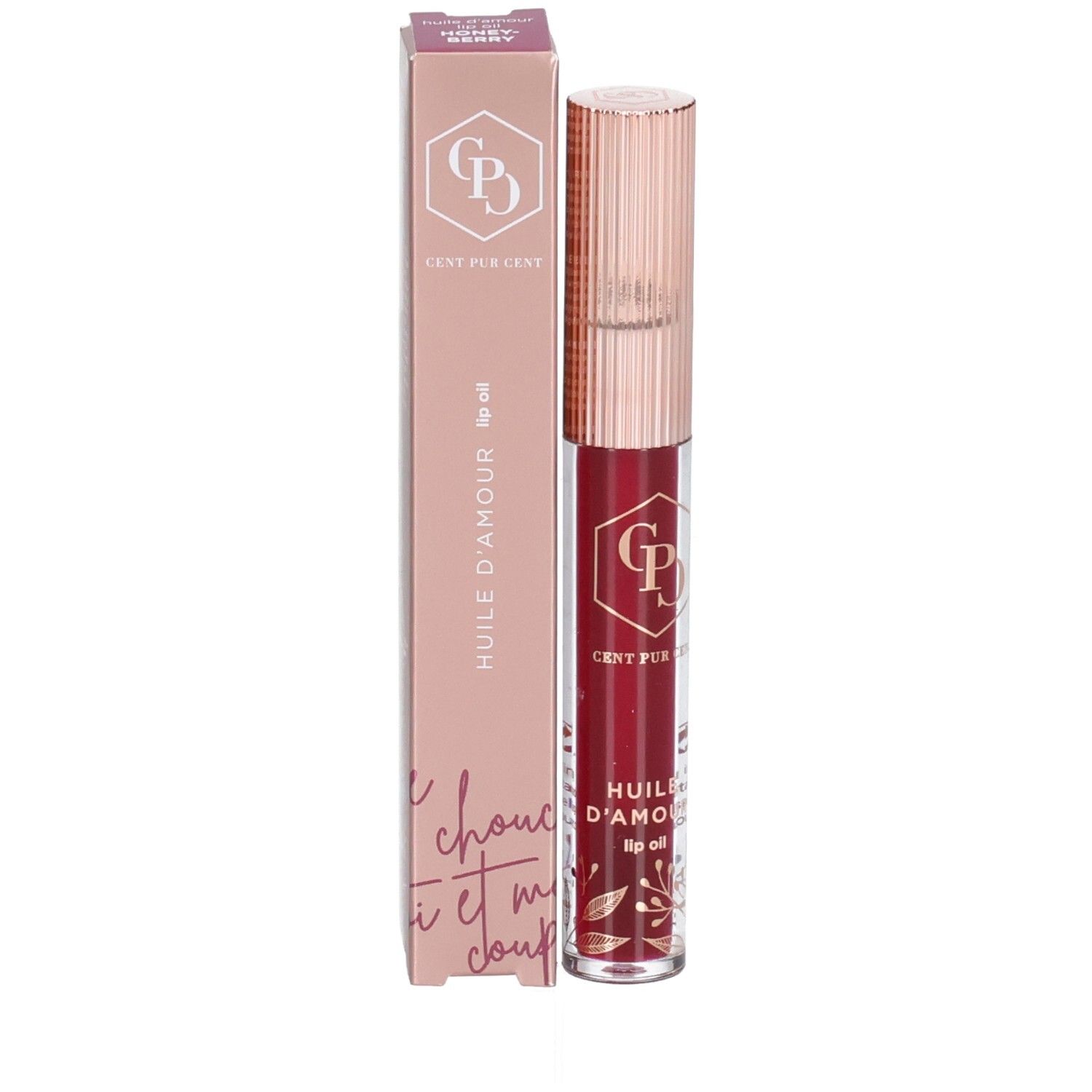 Huile à lèvres et emballage. L'emballage est rose et affiche le nom du produit et le logo. L'huile à lèvres est dans un flacon transparent.
