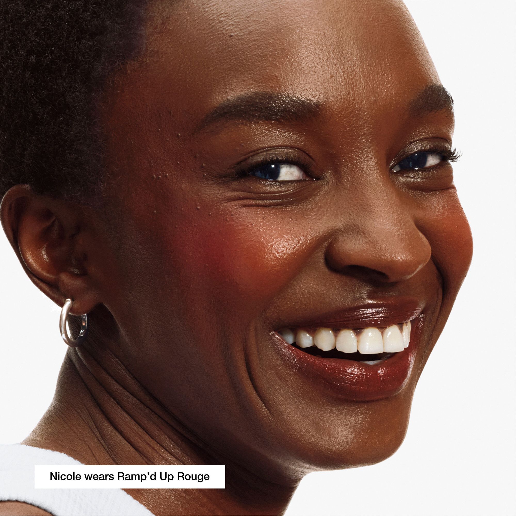 Frau mit Rouge. Produktname 'Ramp'd Up Rouge' sichtbar. Marke nicht genannt.