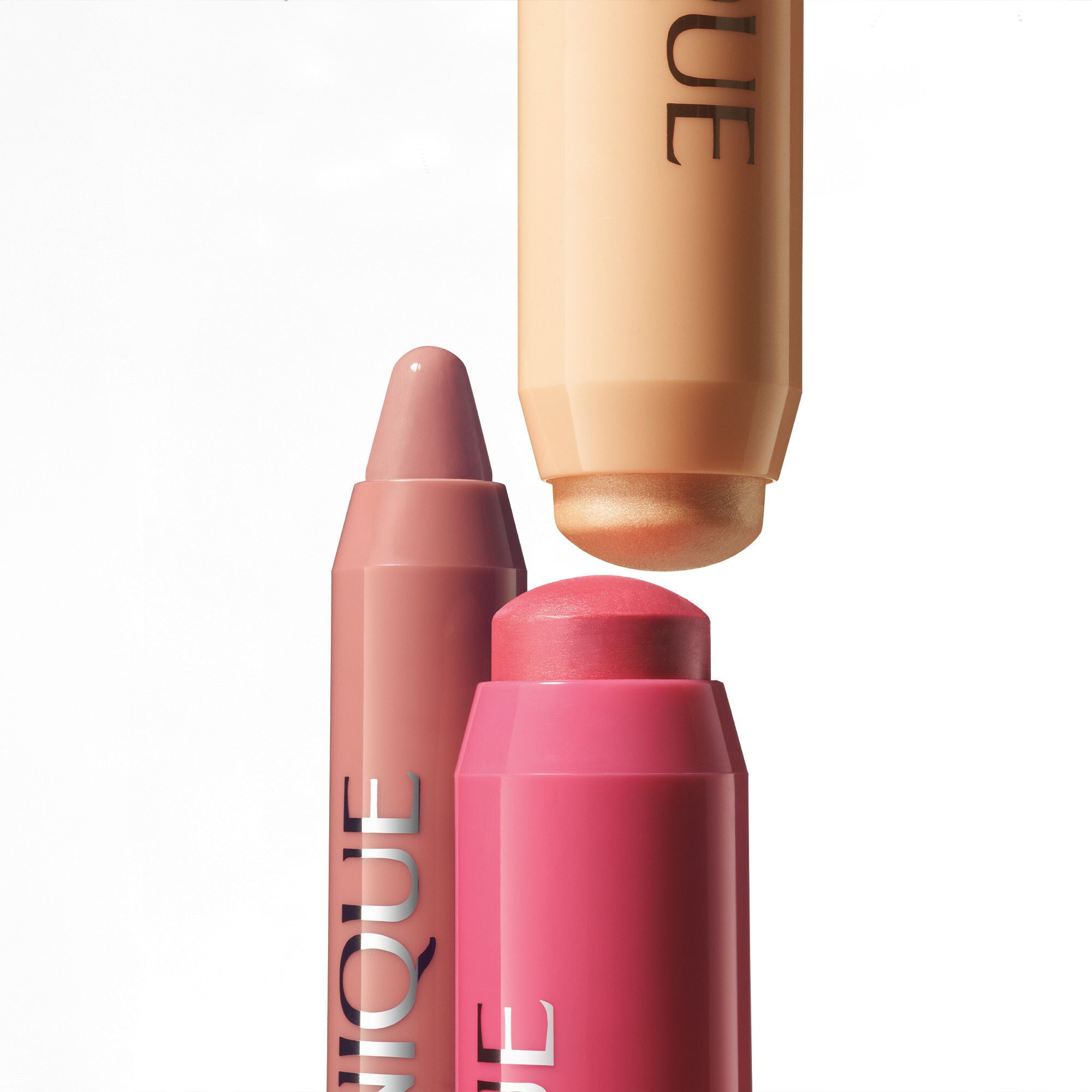 Trois Clinique Chubby Sticks. Rose, brun clair et beige. La marque Clinique est visible.