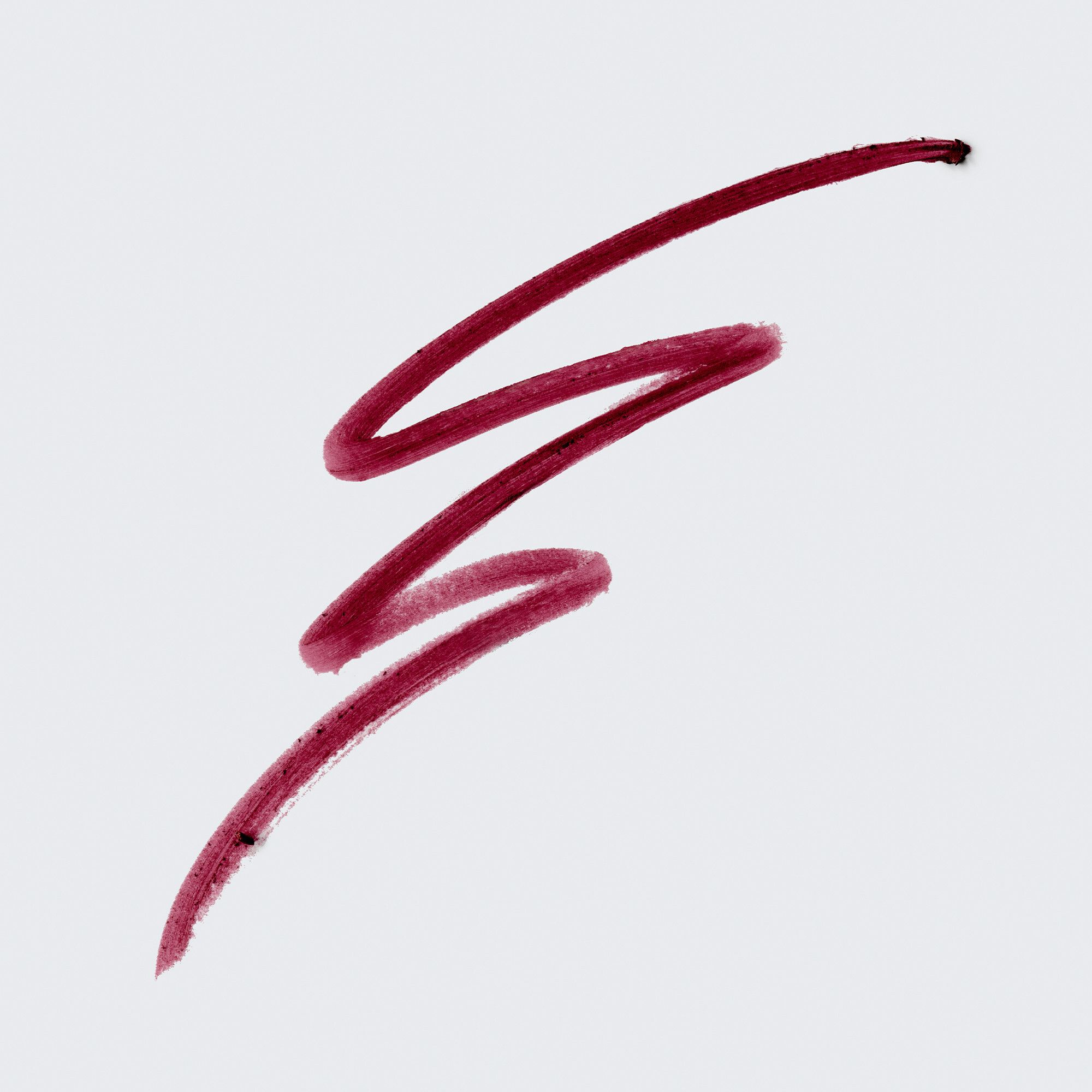 Braune Lippenkonturenstift-Spur auf weißem Hintergrund. Die Spur ist wellenförmig.