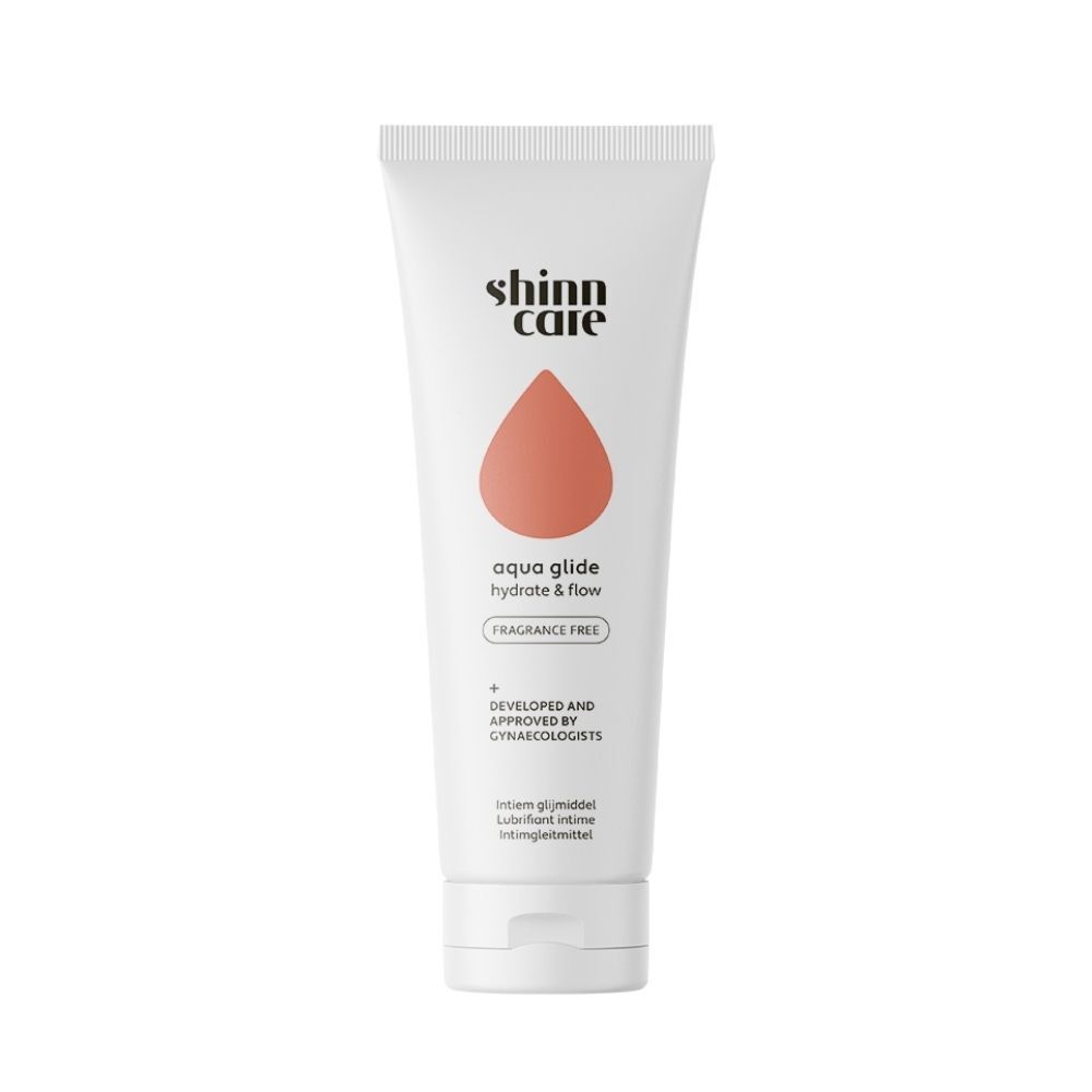 Tube blanc avec nom du produit et goutte orange. Texte: aqua glide, hydrate & flow, sans parfum.