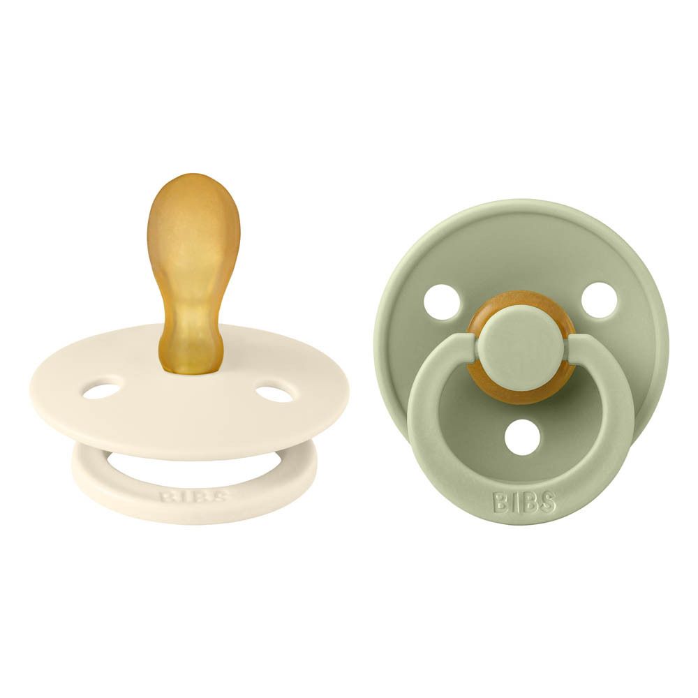 Deux sucettes, une ivoire, une sauge. Forme ronde, tétine en silicone, bouclier avec logo BIBS.