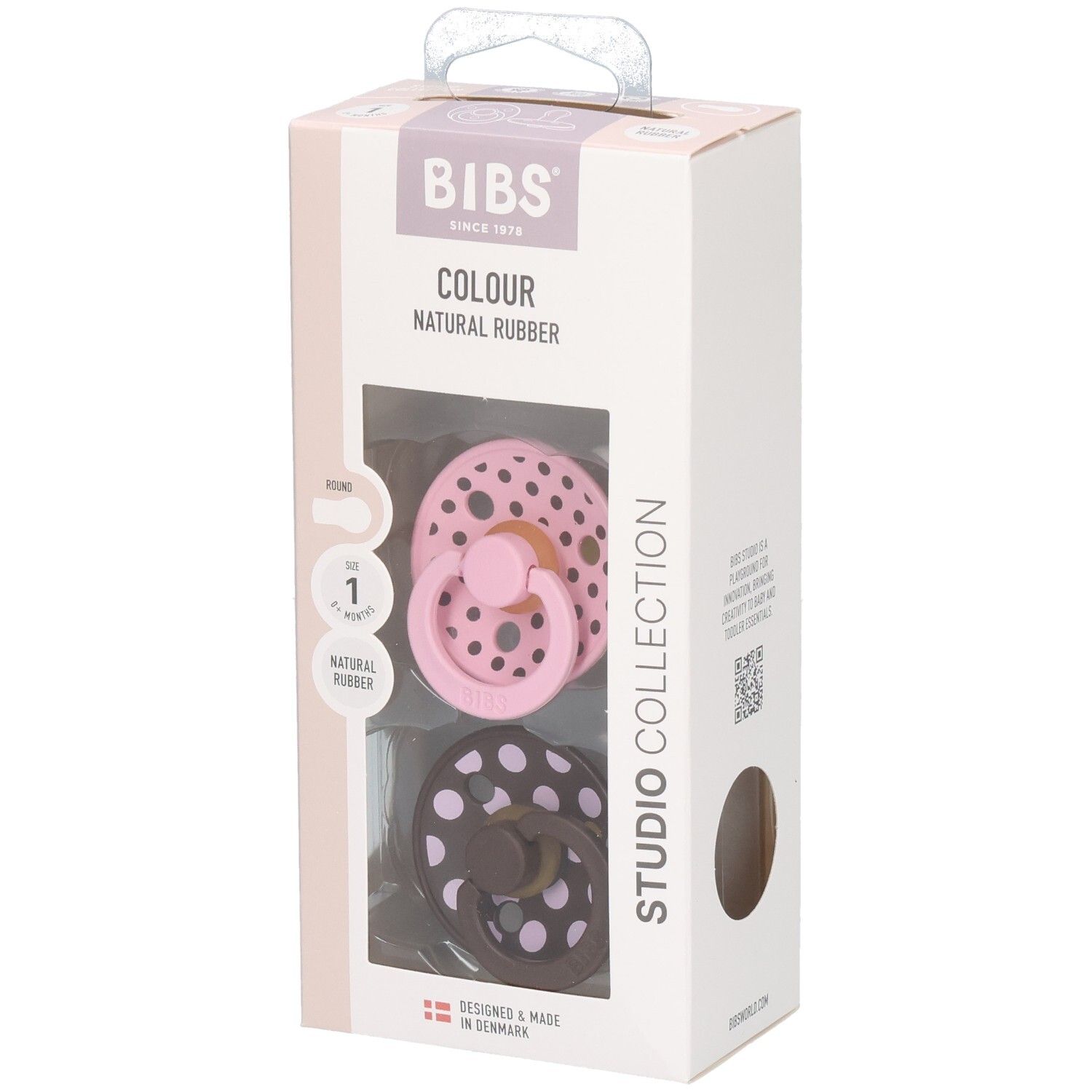 Verpackung mit zwei Schnullern. Rosa und braun mit weißen Punkten. Marke: BIBS. Sichtfenster.