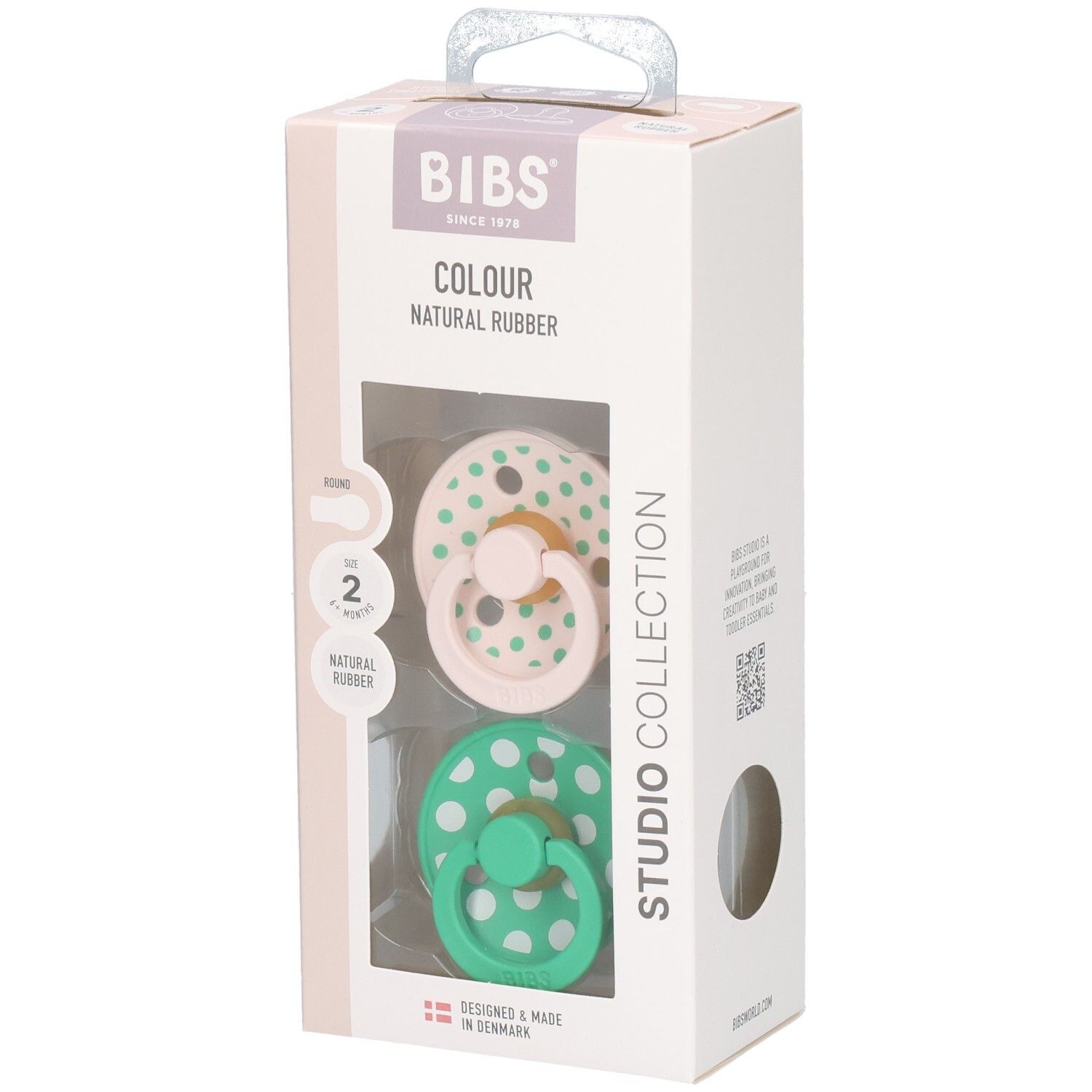 Boîte de deux sucettes. Sucettes roses et vertes à pois blancs. Marque : BIBS. Caoutchouc naturel.