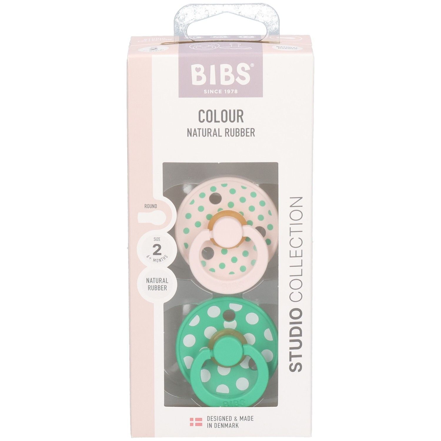 Boîte de deux sucettes. Sucettes roses et vertes à pois blancs. Marque : BIBS. Caoutchouc naturel.