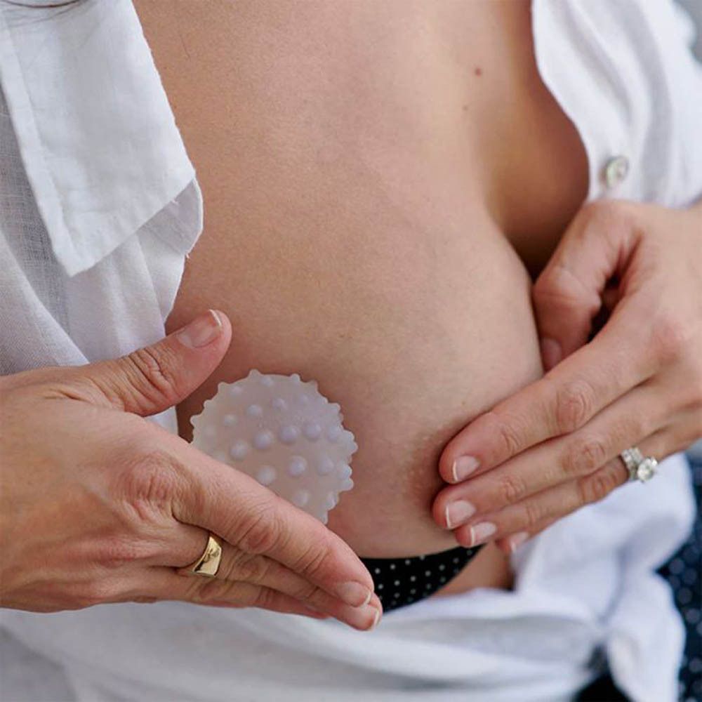 Masseur de sein Lactamo dans son emballage cylindrique. "Here to help with breastfeeding" et "1x super soft gel filled breastfeeding ball" sont imprimés.