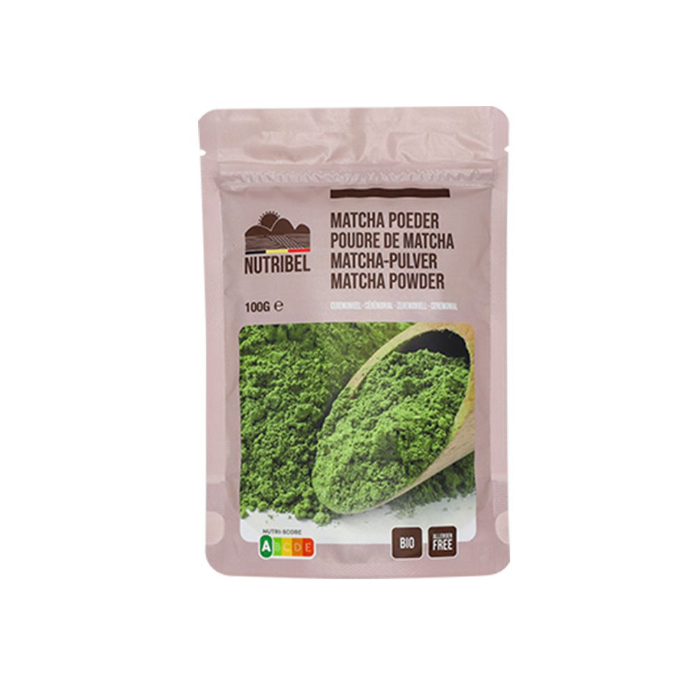 Sachet de poudre de matcha Nutribel. Inscription : Matcha Poeder, 100g, Bio, sans gluten. Poudre verte dans une cuillère en bois.